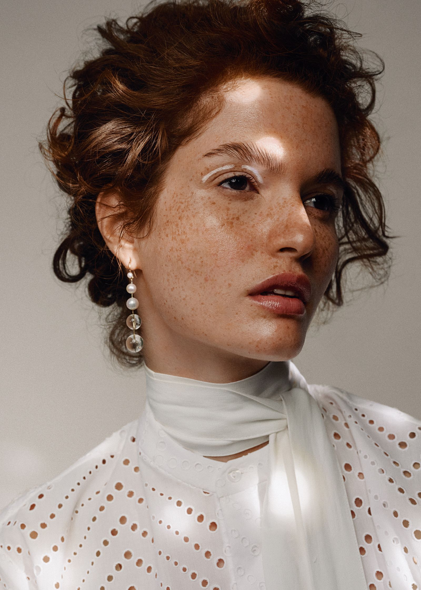 a woman with freckles wearing a white shirt