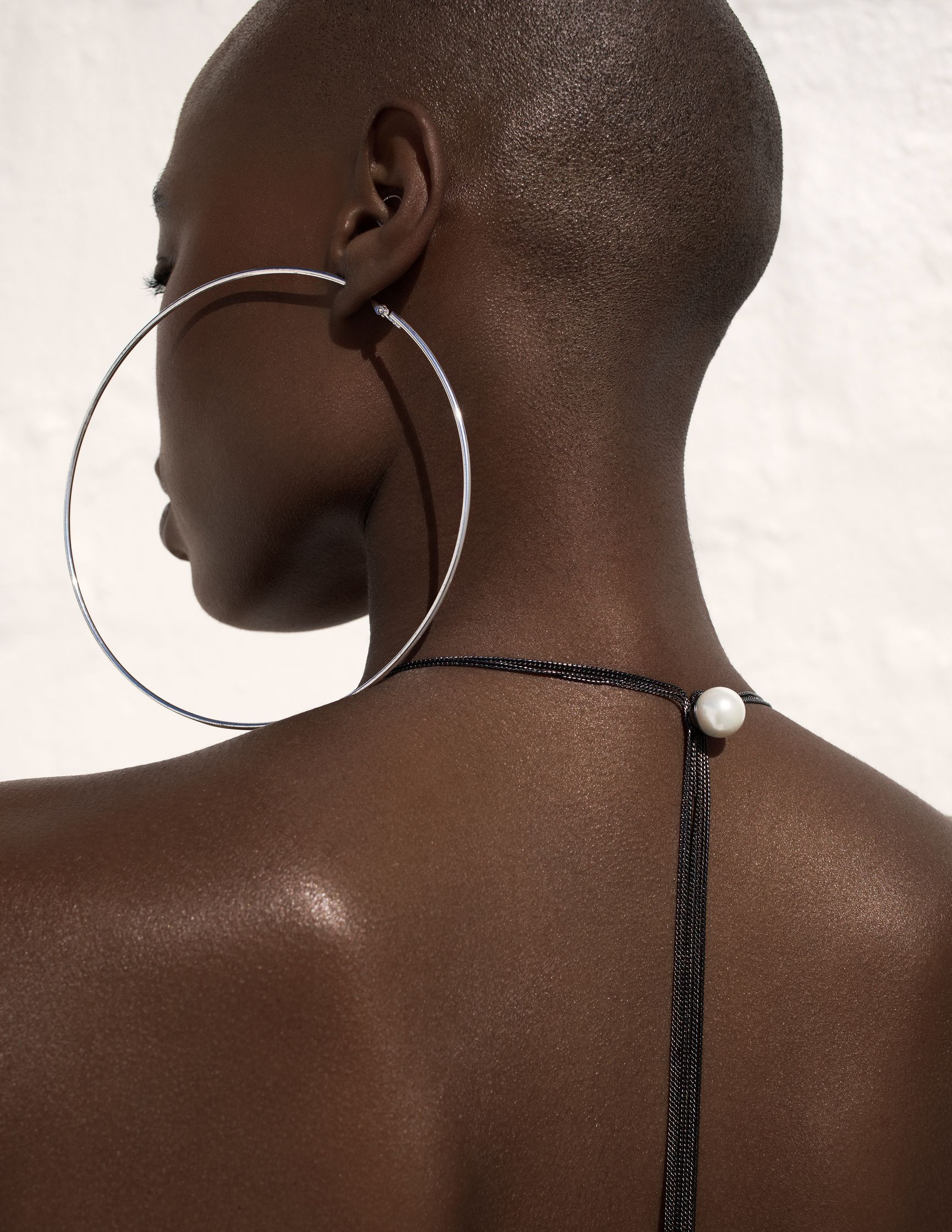 the back of a black woman wearing a hoop earring