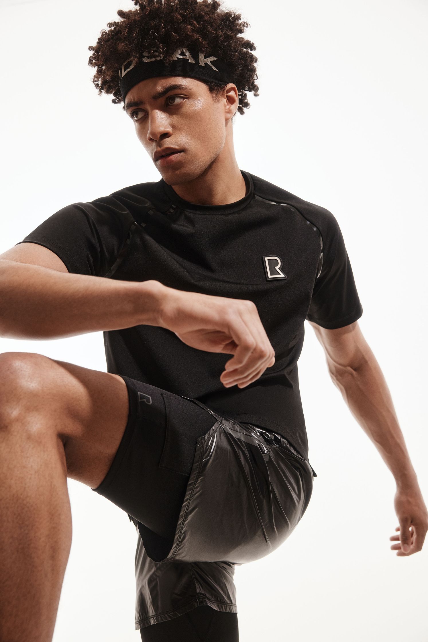a man wearing a black t - shirt and shorts