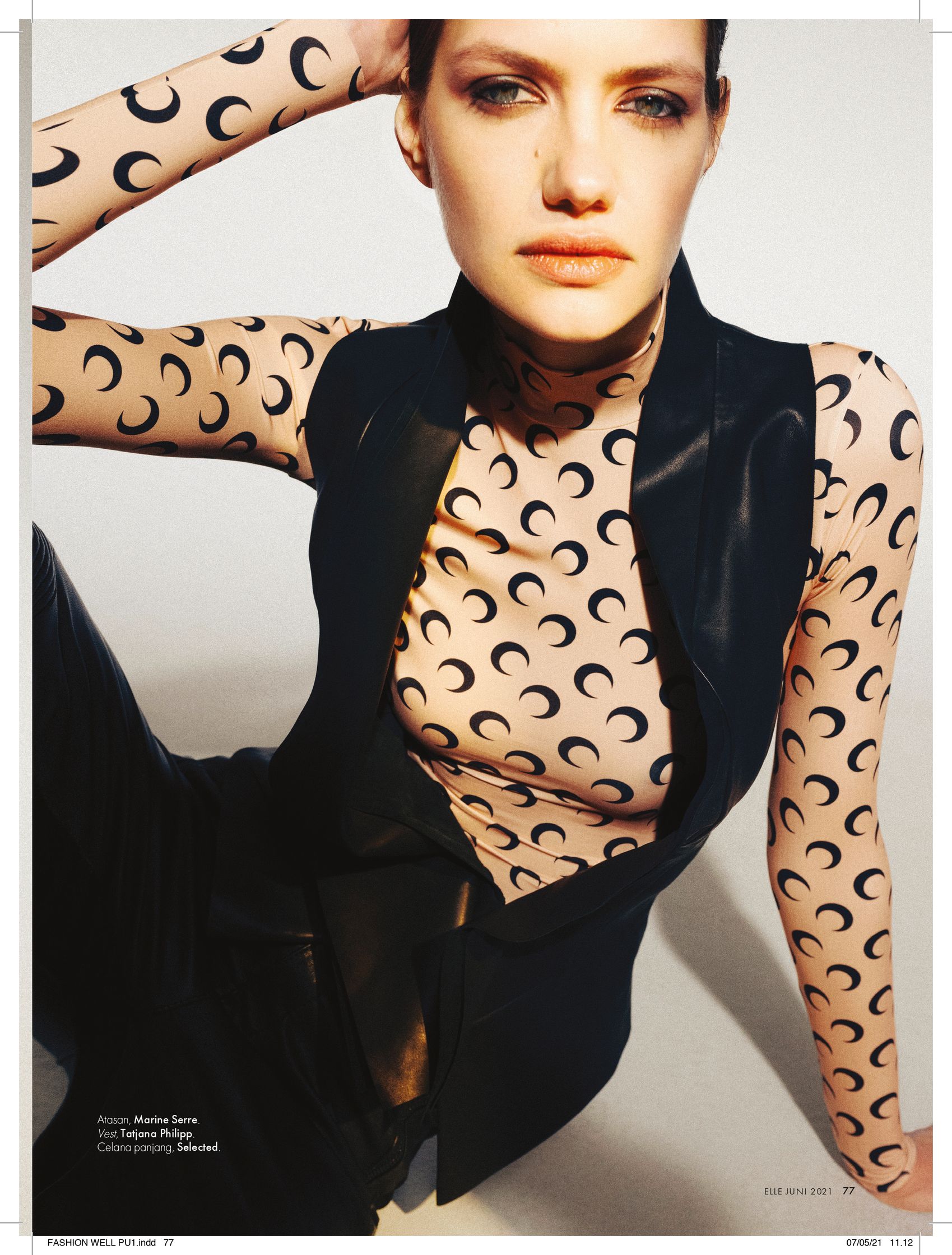 a model in a black and white outfit posing for a magazine