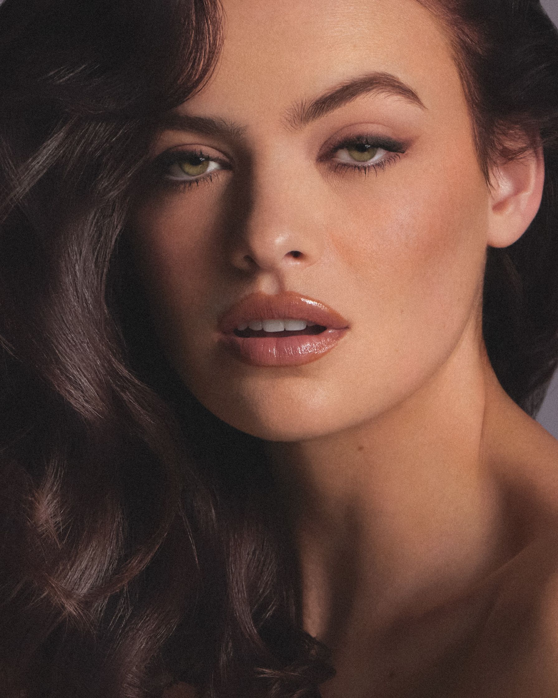 a woman with long brown hair posing for a magazine