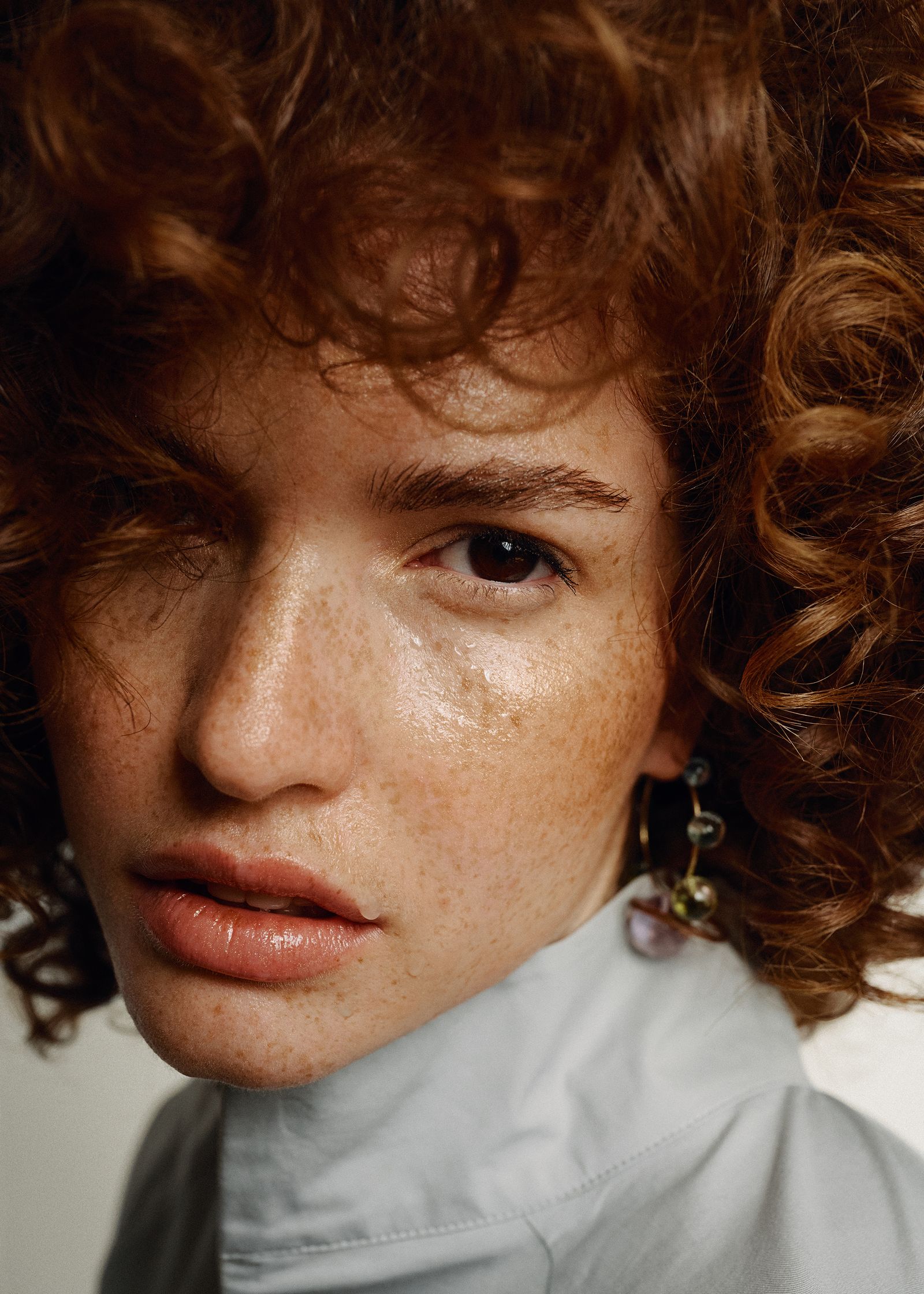 a woman with red curly hair is posing for a photo