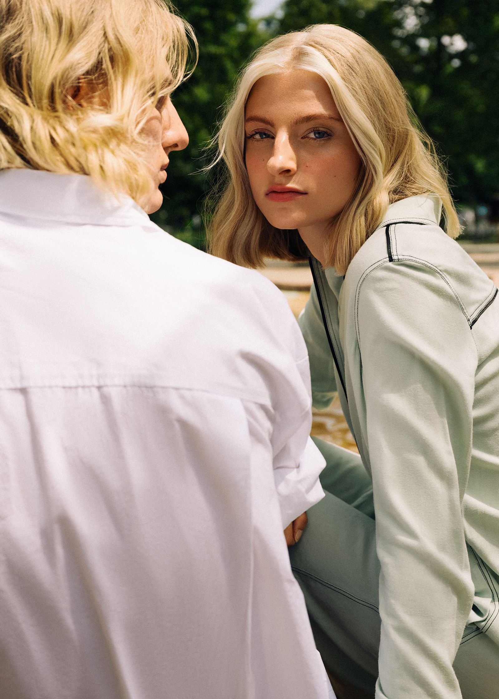 a woman and a man sitting on a bench looking at each other