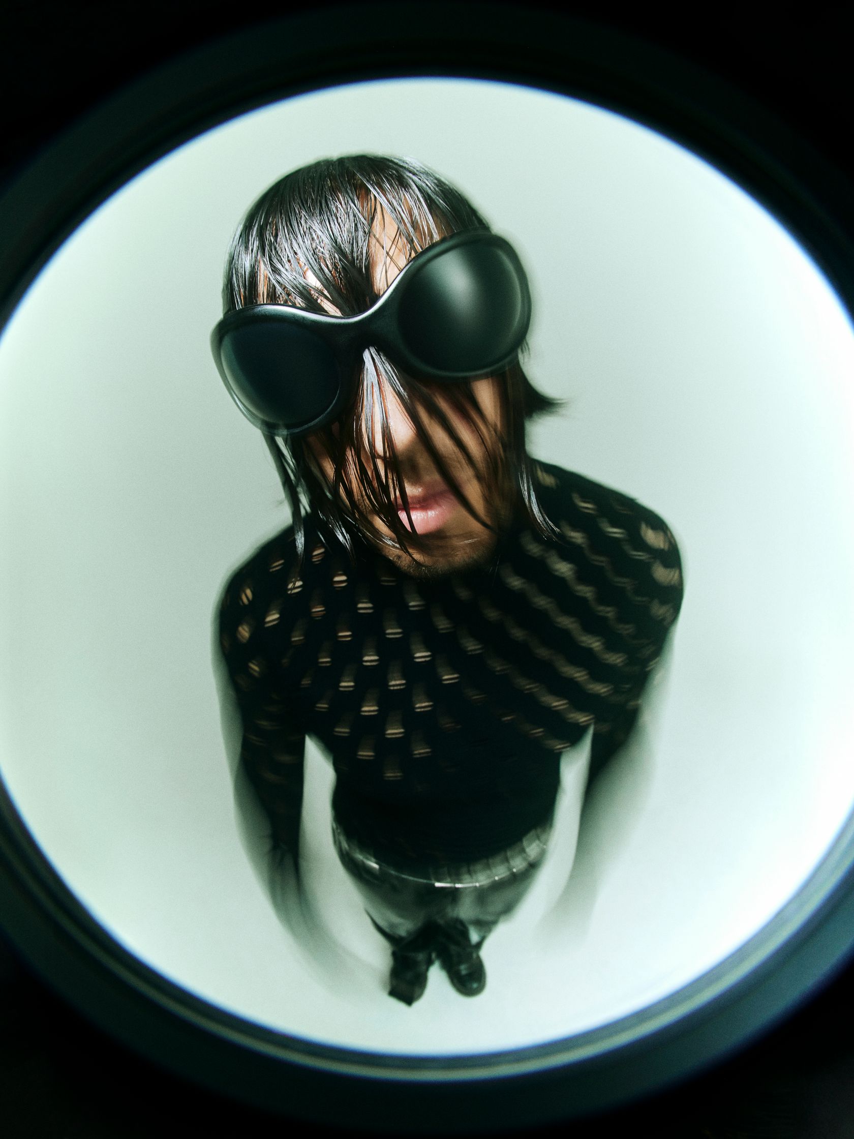 a person in a black outfit is standing in front of a mirror