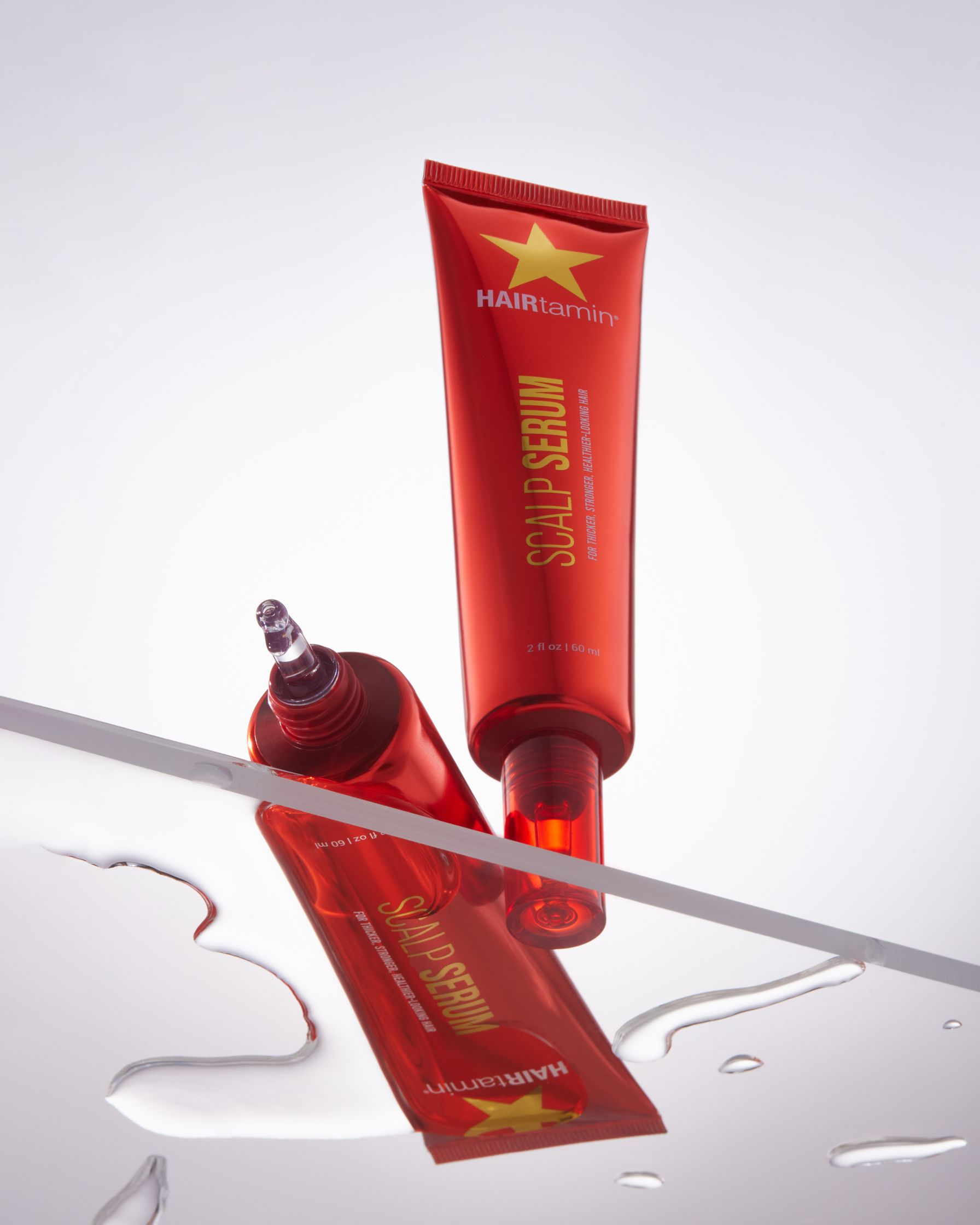 a tube of red cream sitting on top of a glass