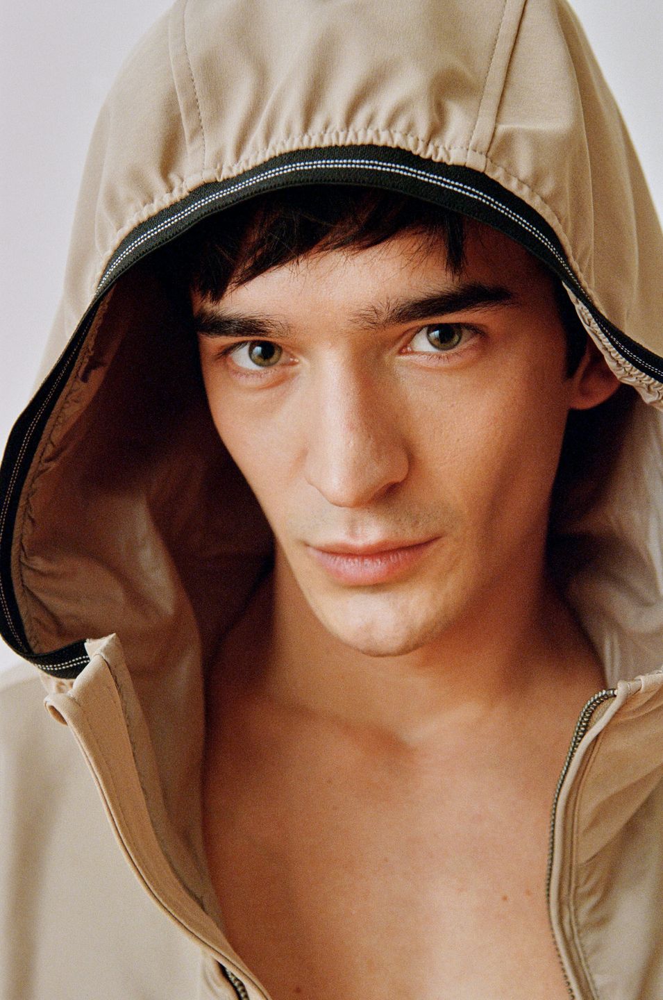 a man in a hooded jacket is posing for a photo by advertising photographer Martin Kula