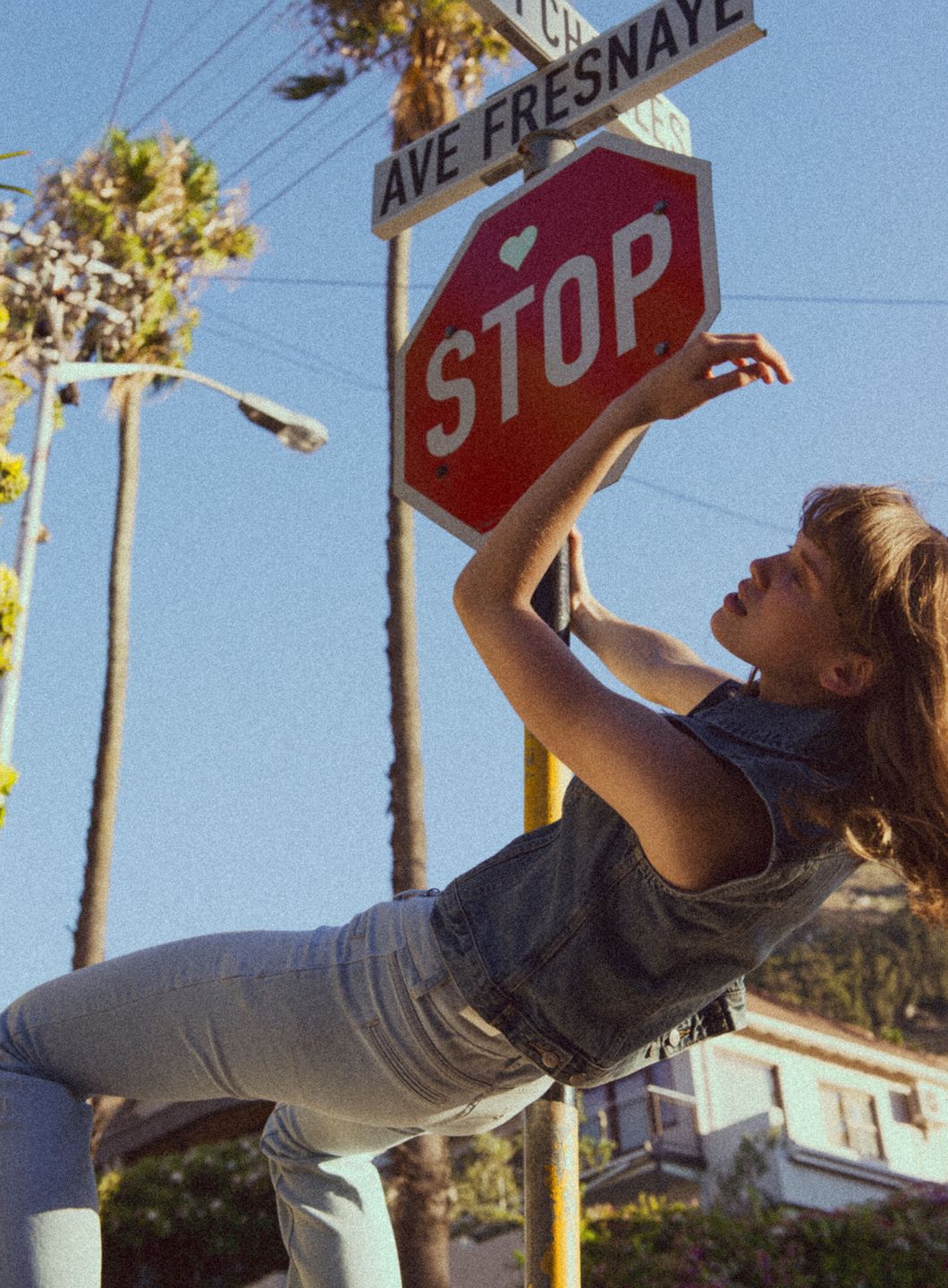 a woman balancing on top of a stop sign by Martin Kula, photographer