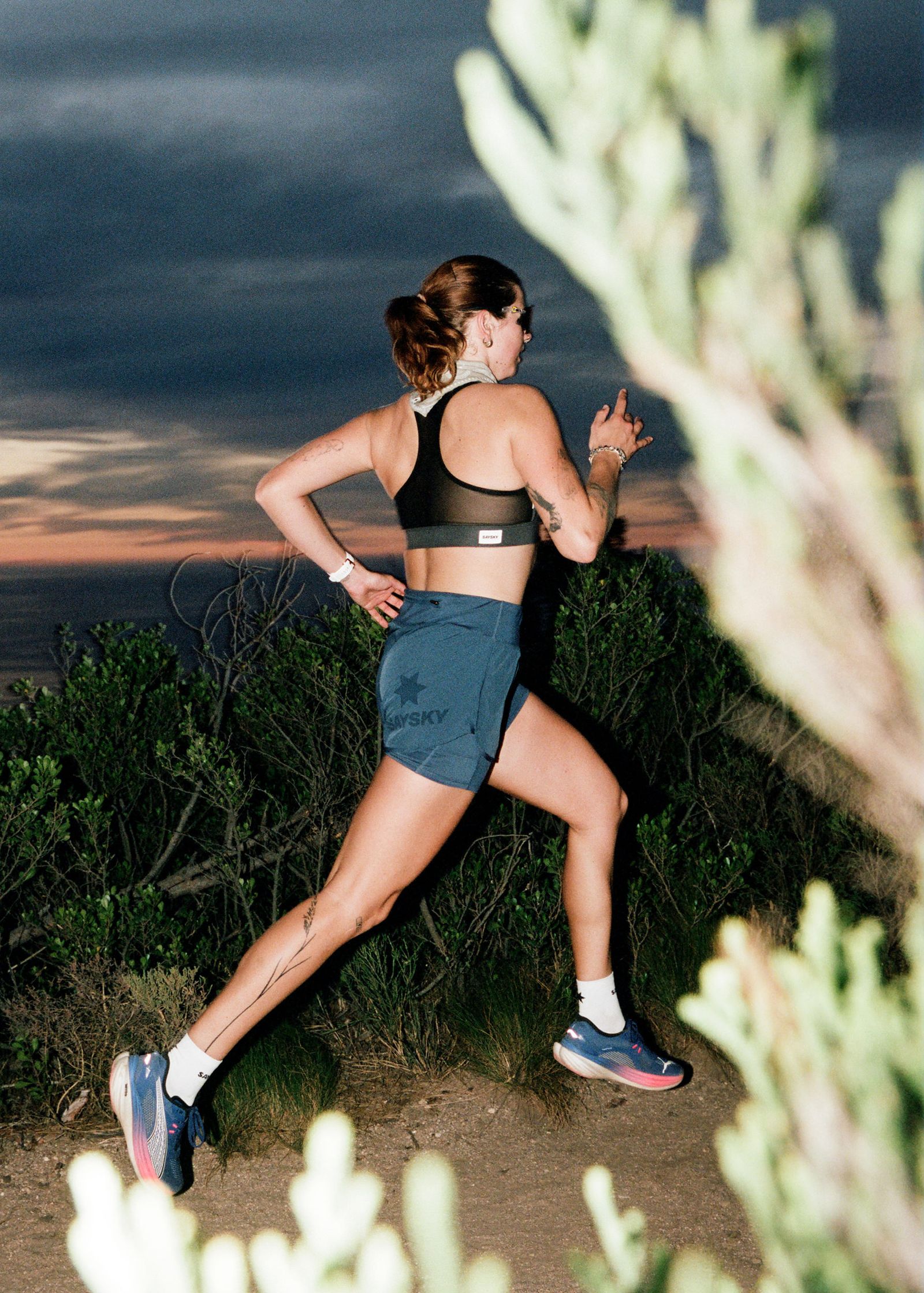 a woman running on a trail at dusk