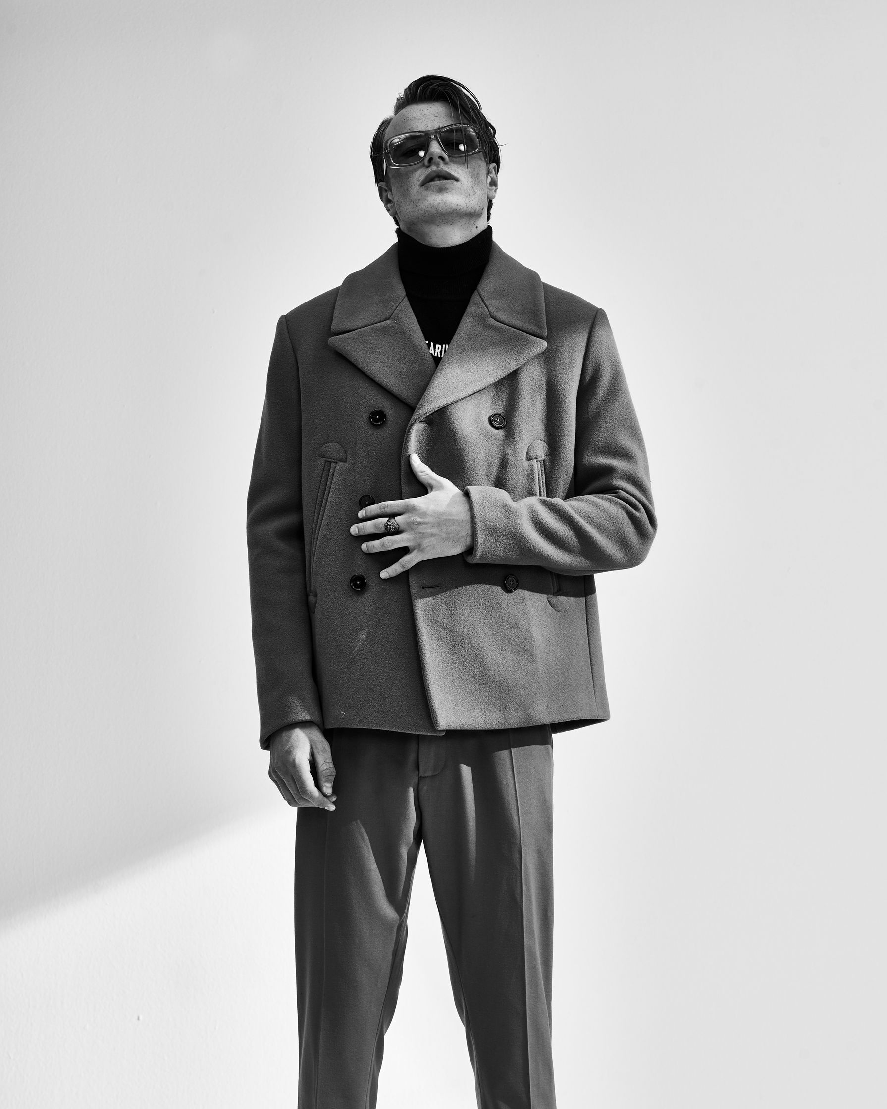 a black and white photo of a man in a suit and sunglasses