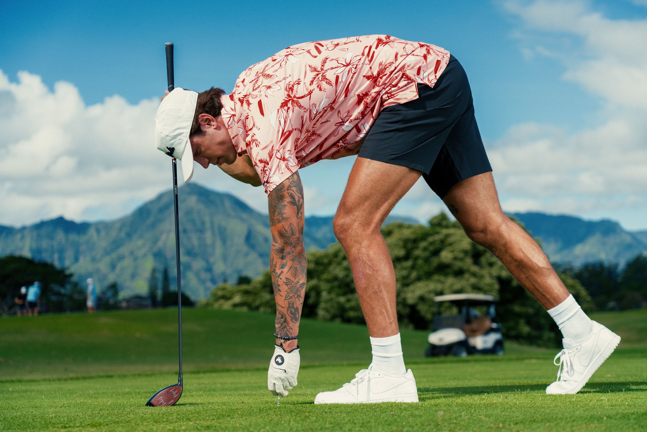 a man bending down to hit a golf ball