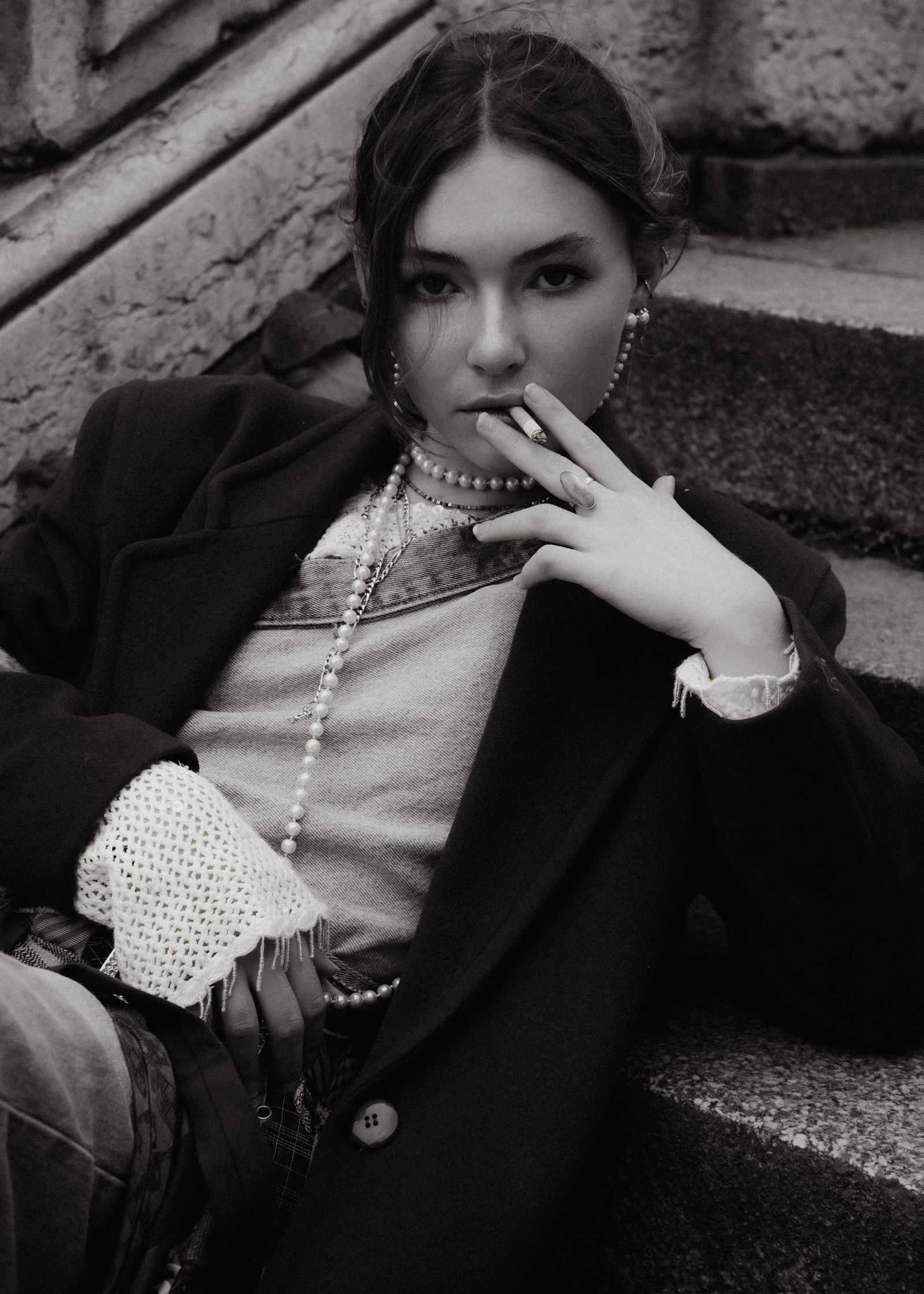 a woman is sitting on steps smoking a cigarette