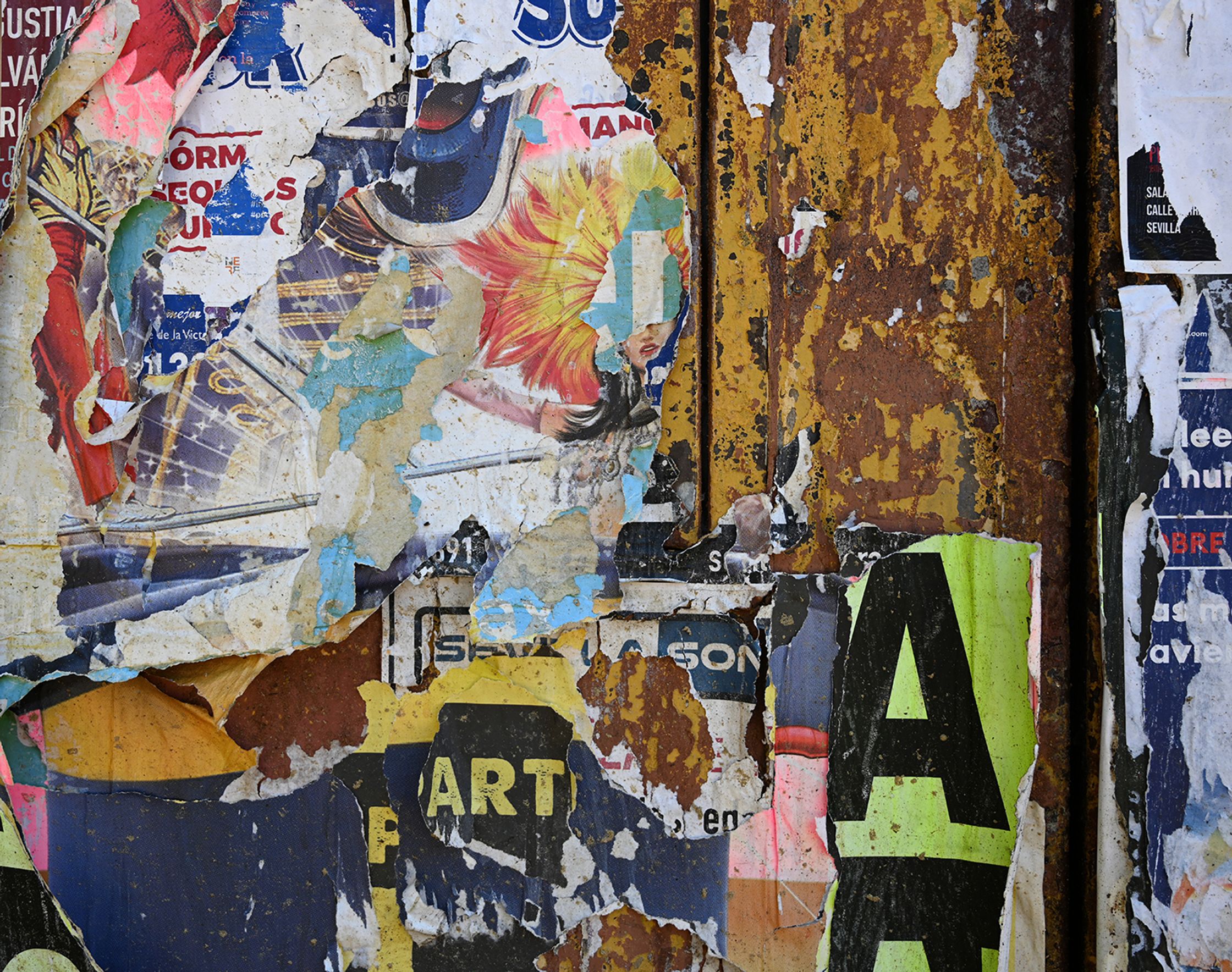 a wall with a lot of torn posters on it looking like a collage
