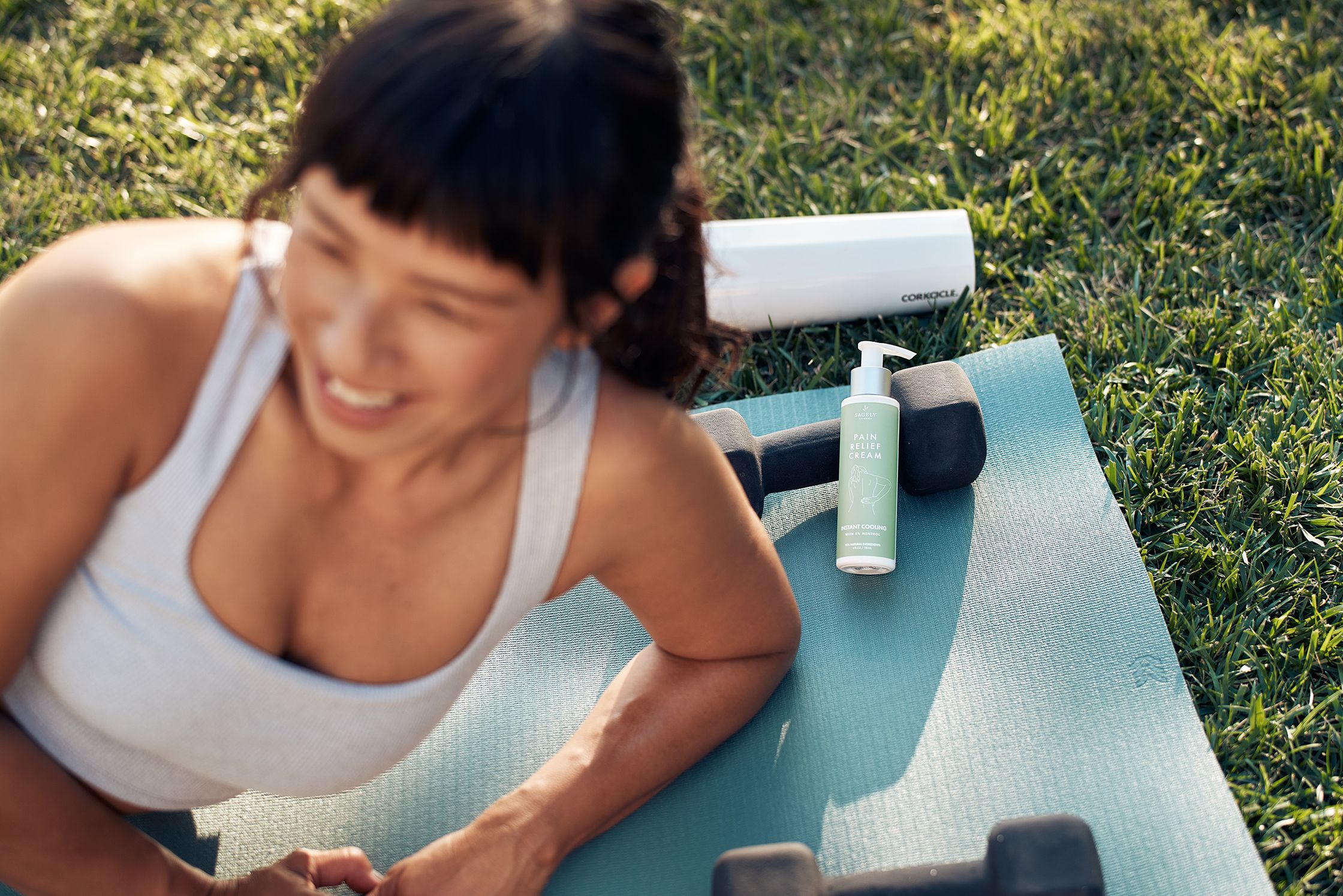 a woman laying on a yoga mat with dumbbells