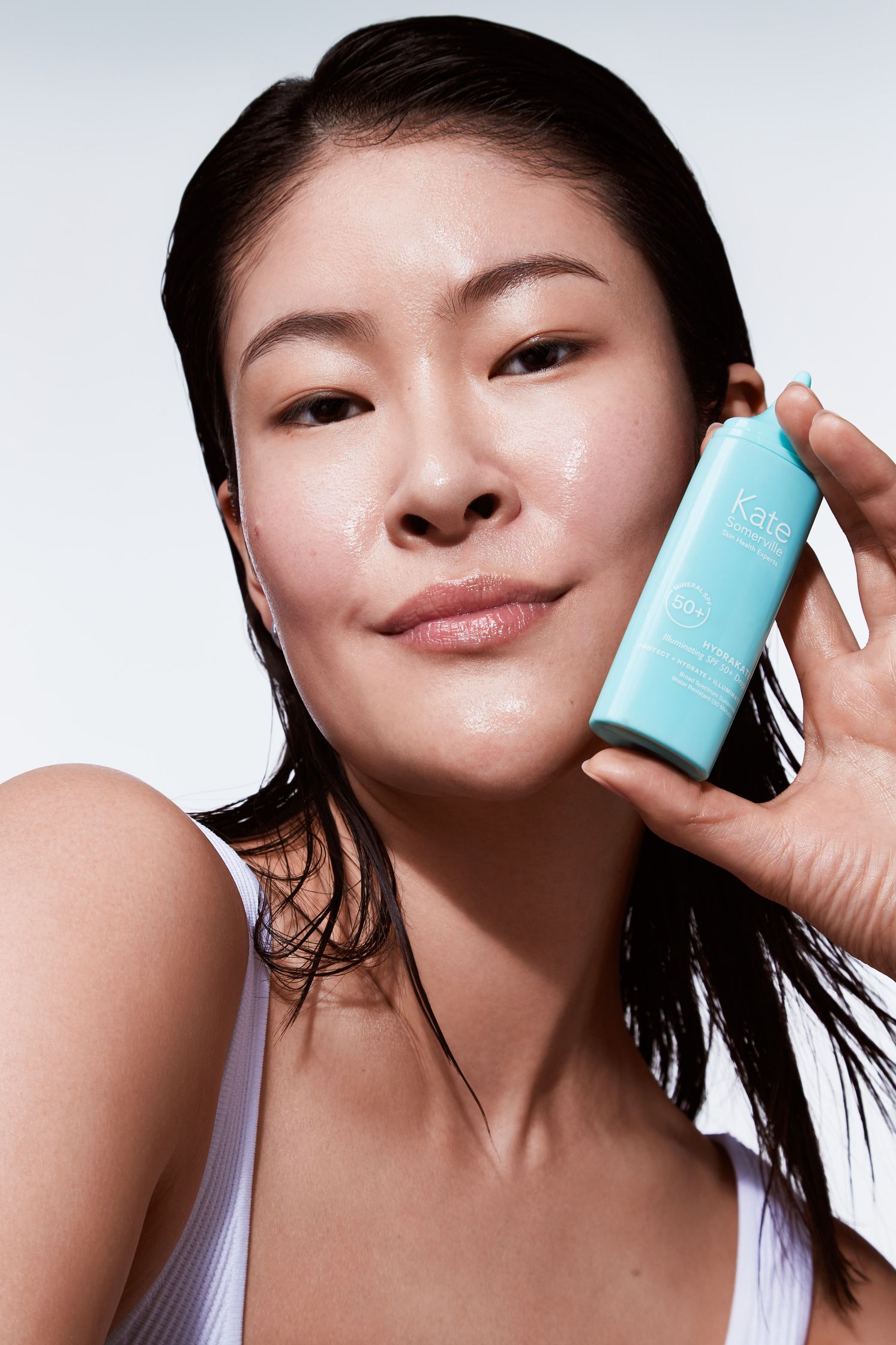a woman holding a bottle of moisturizer in her hand