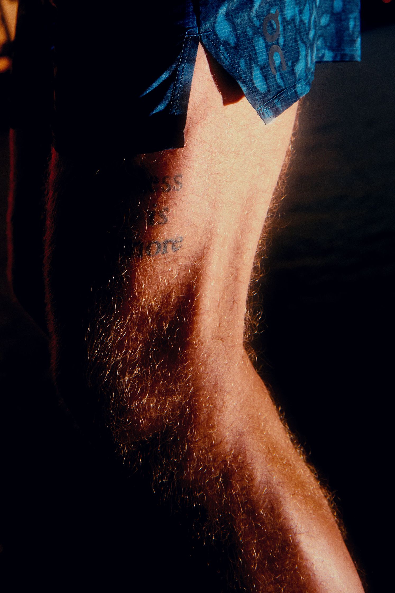 a man with a tattoo on his leg, running, by Martin Kula, photographer