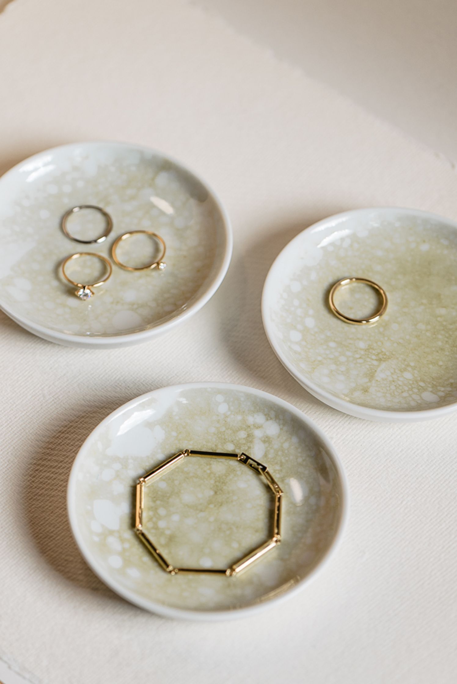a set of plates with gold rings on them by maren jewellery
