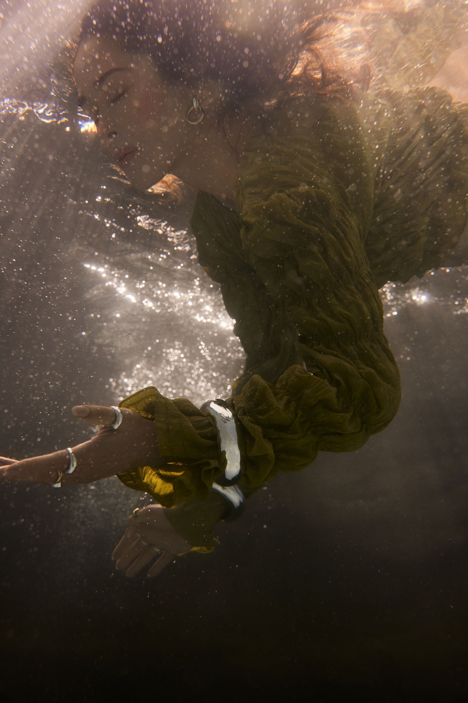 a woman in a green dress swimming in the water
