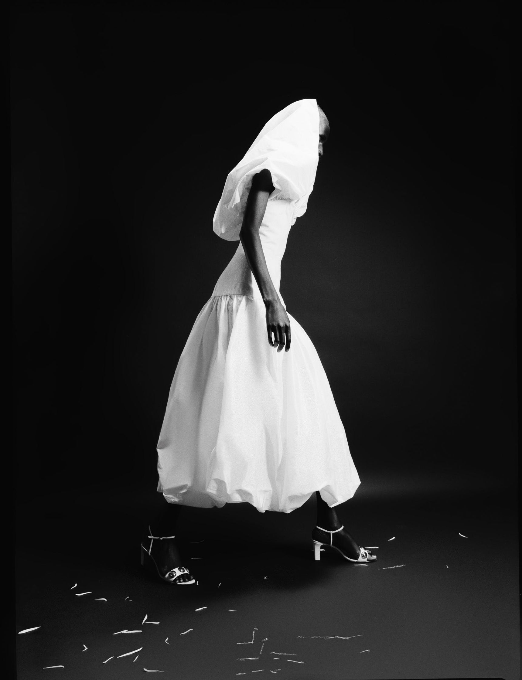 a black and white photo of a woman in a white dress