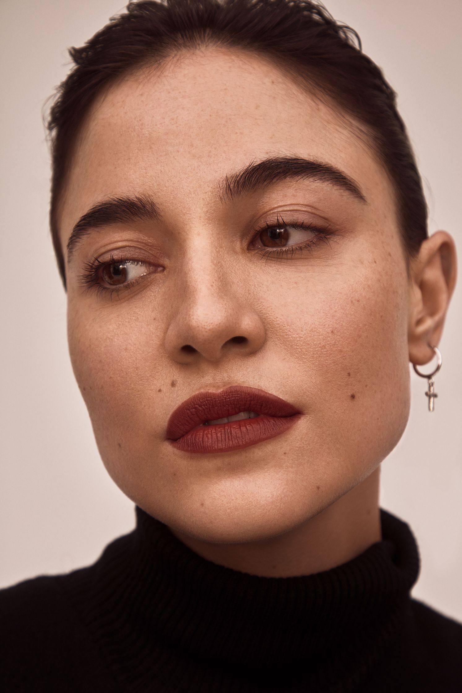 a woman wearing a black turtleneck and red lipstick