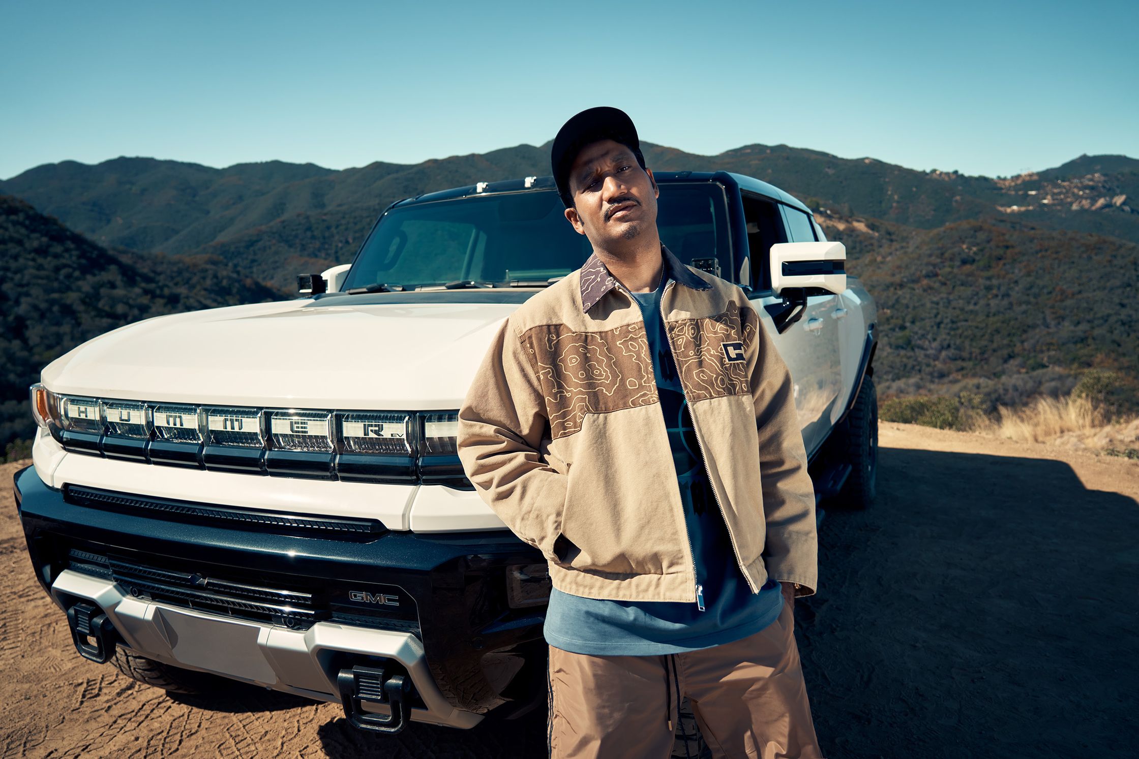 a man standing in front of a Hummer EV
