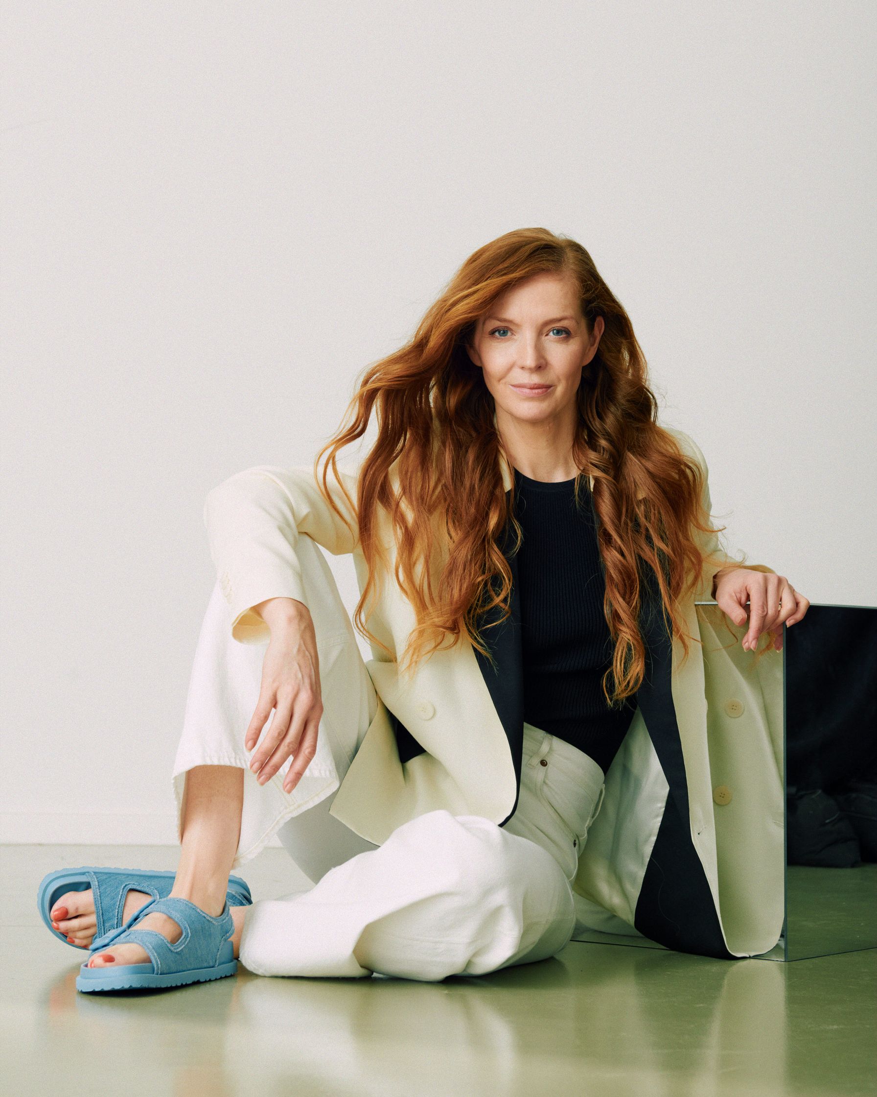 Pheline Roggan on the floor in a white blazer and white pants