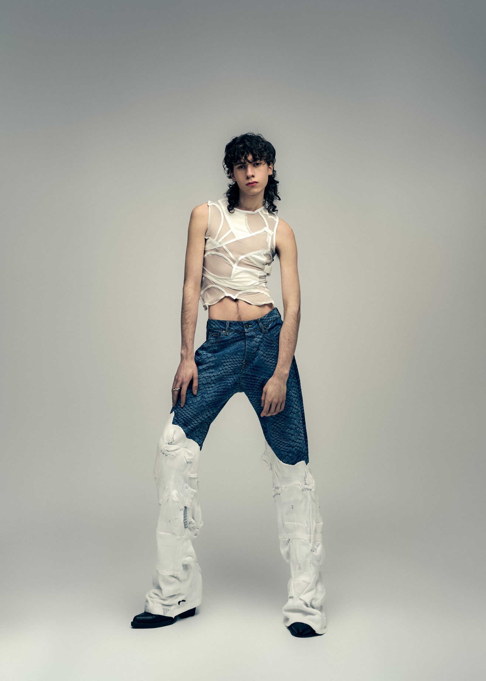 a woman in a white top and jeans posing on a gray background
a studio fashion editorial