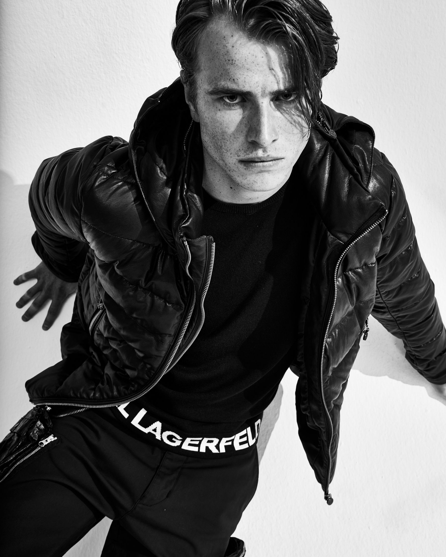 a black and white photo of a man in a jacket and pants