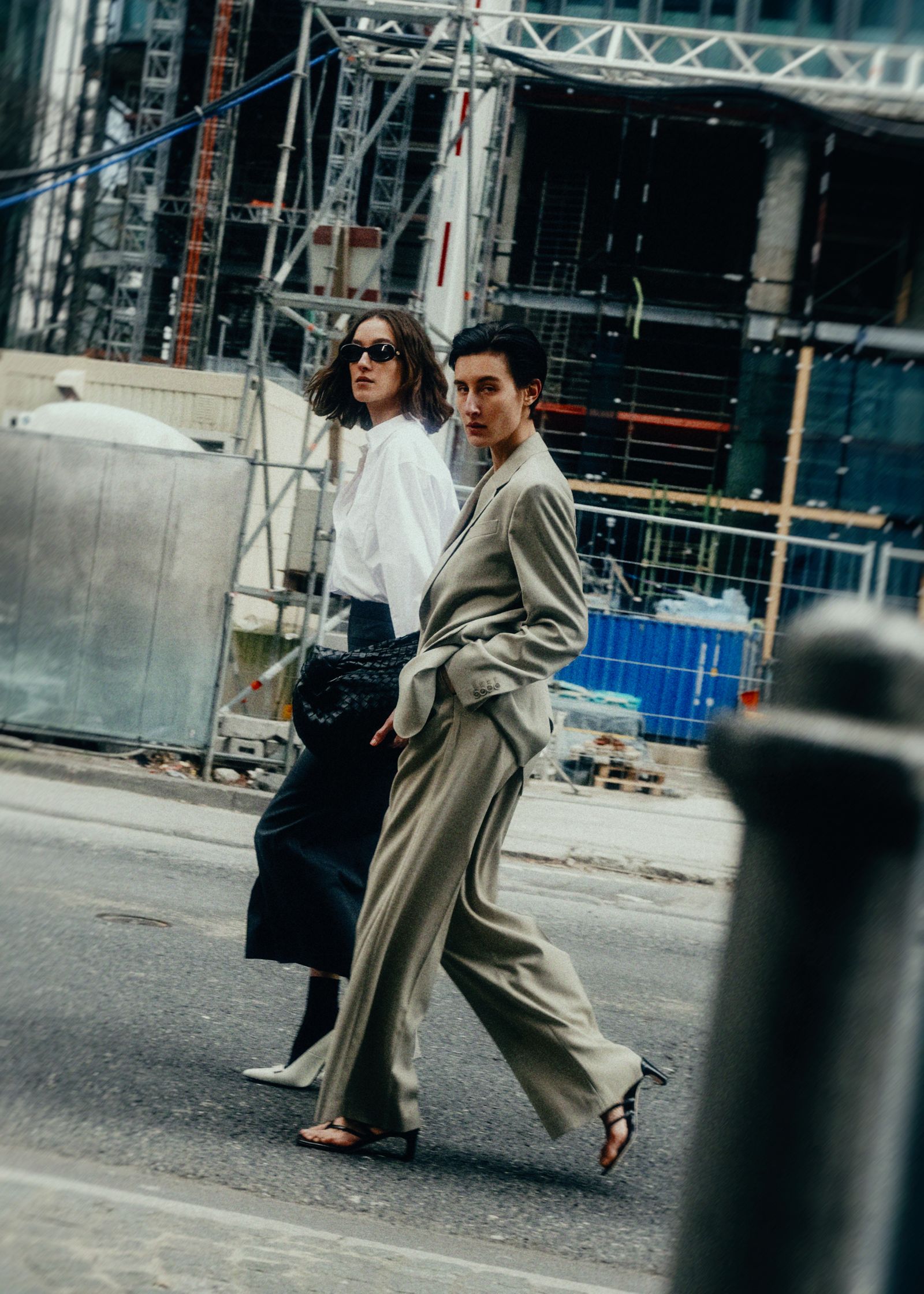 two women walking down the street in a suit