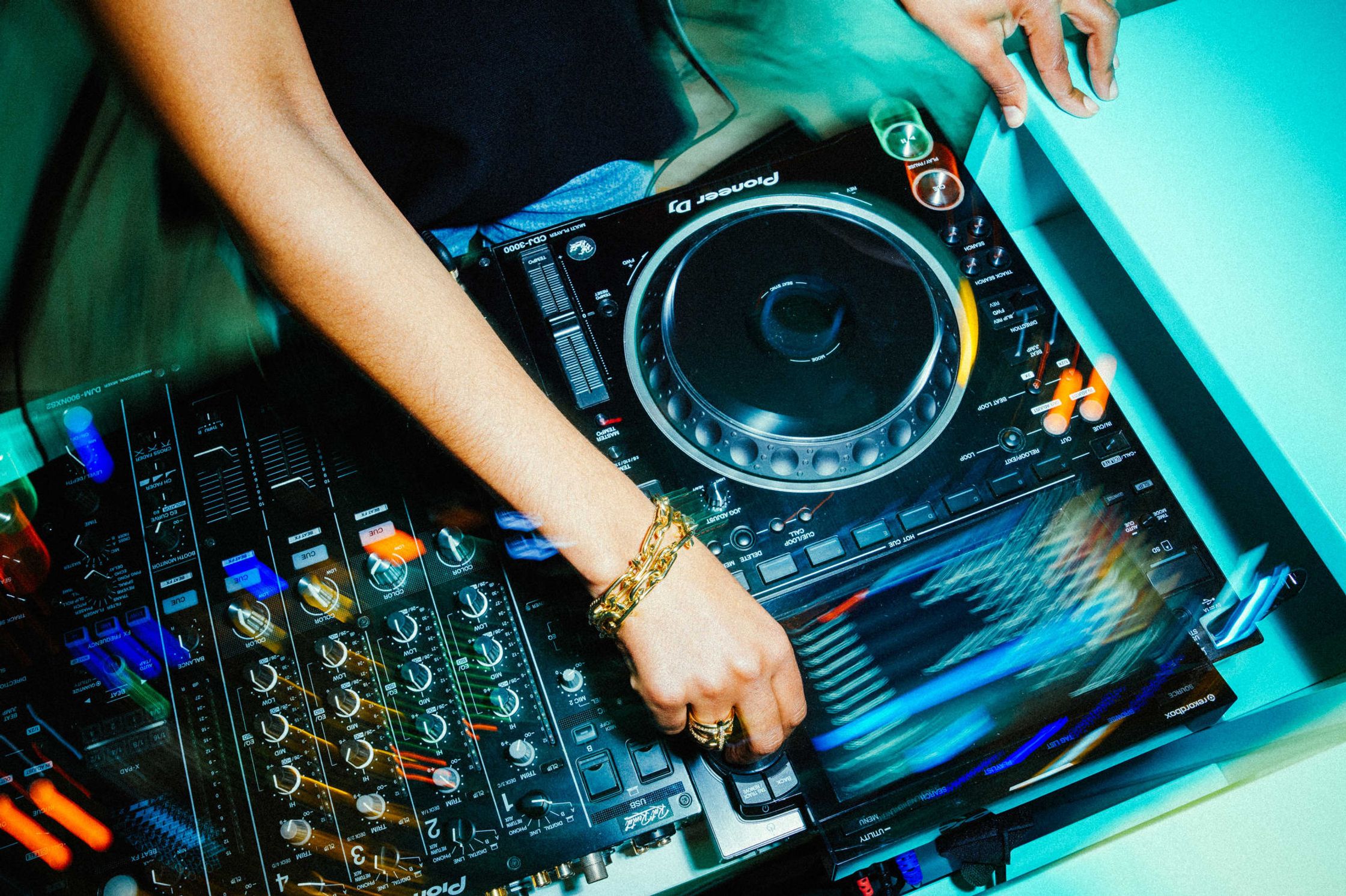 DJ-Hände an Pioneer CDJ-3000 und Mischpult beim Tiffany & Co. Event Berlin – goldenes Kettenarmband und Ring im blauen Licht