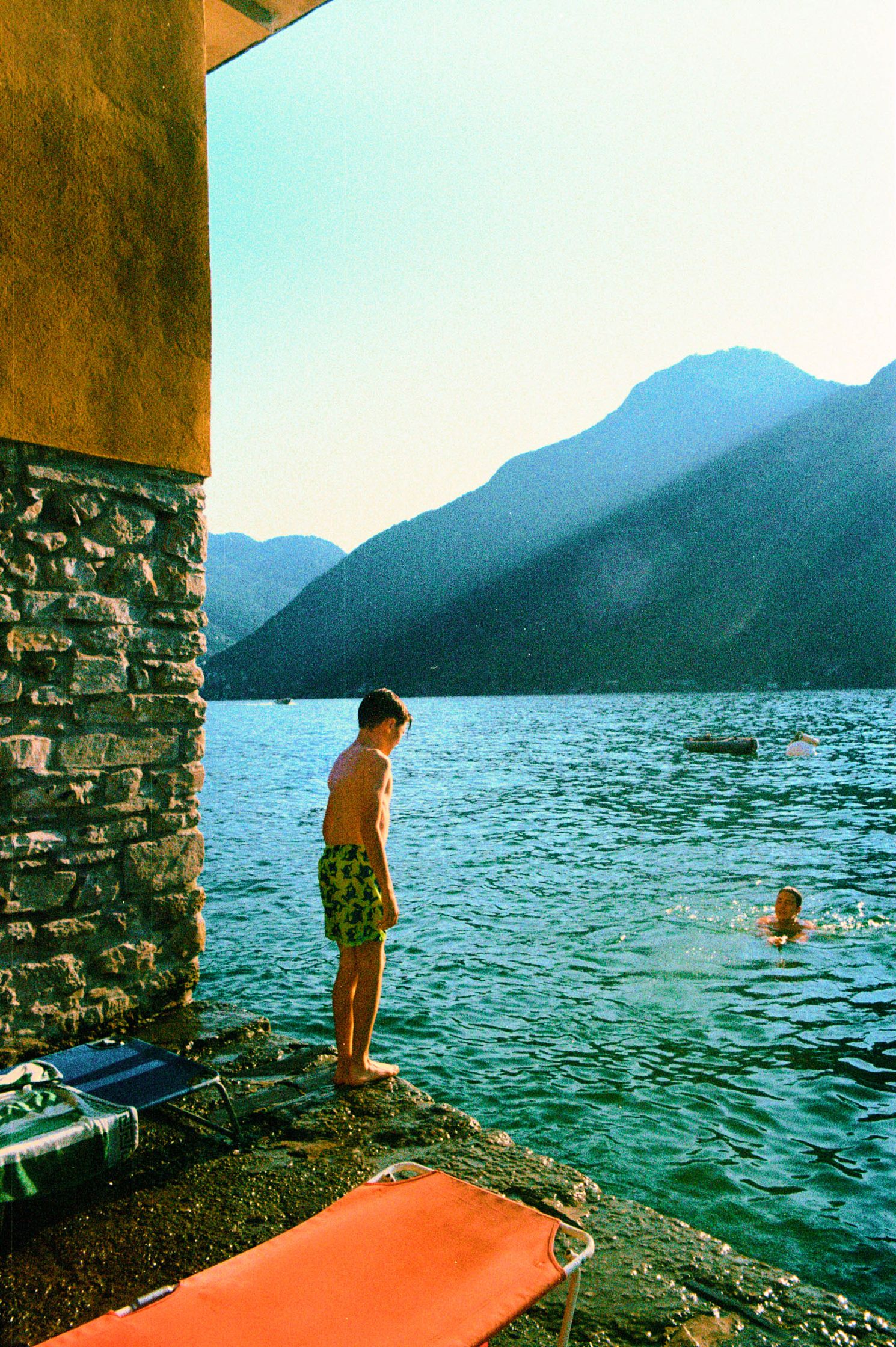 Captured at Lake Como in the middle of summer, it freezes the silent waiting and the escape of childhood by the water.