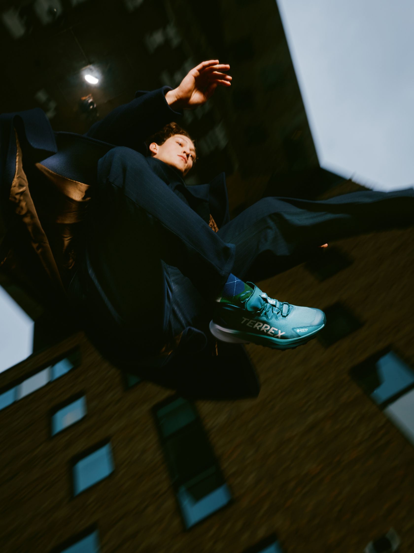 a man is jumping in the air in front of a building