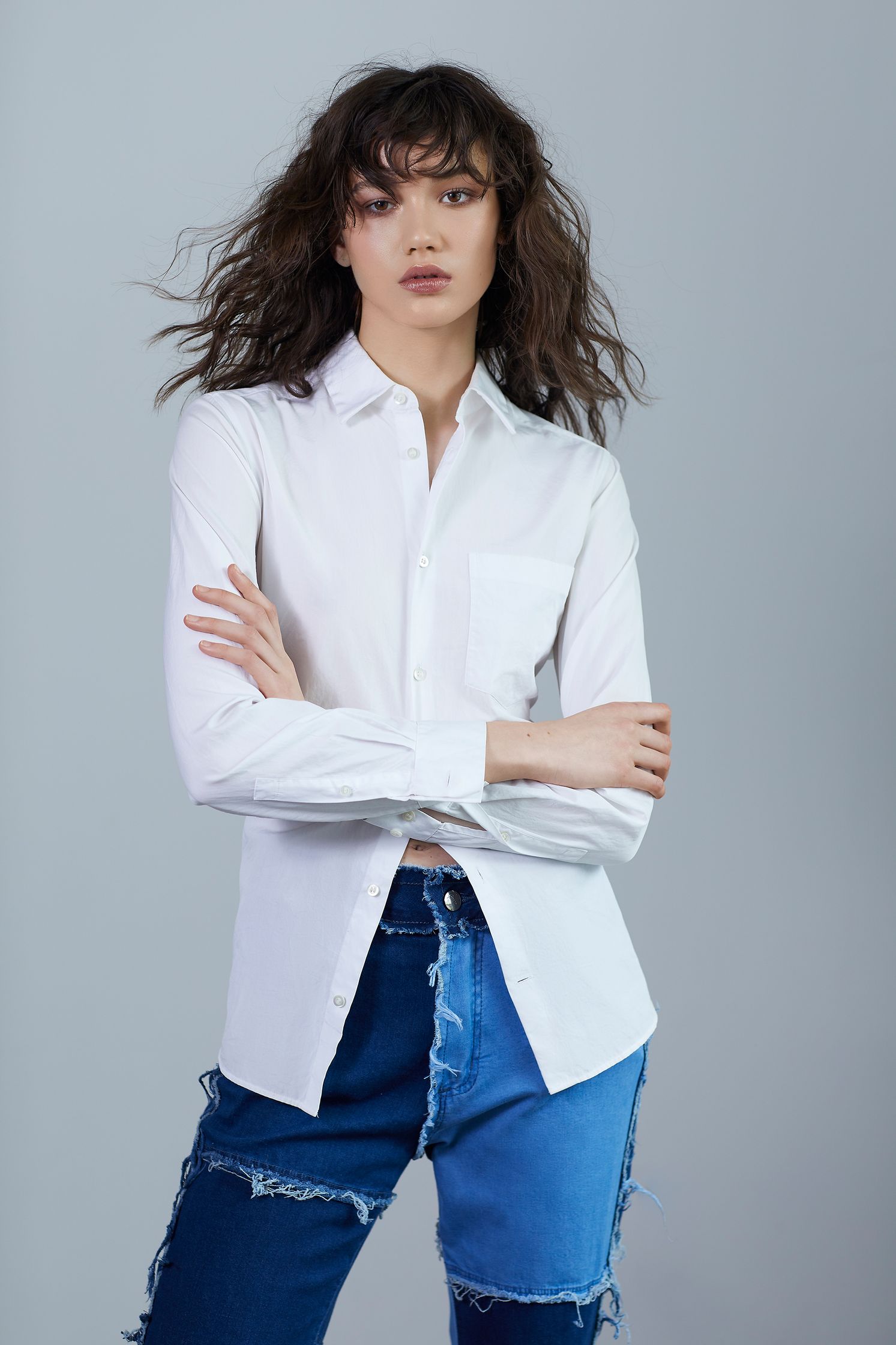 a model wearing a white shirt and blue jeans