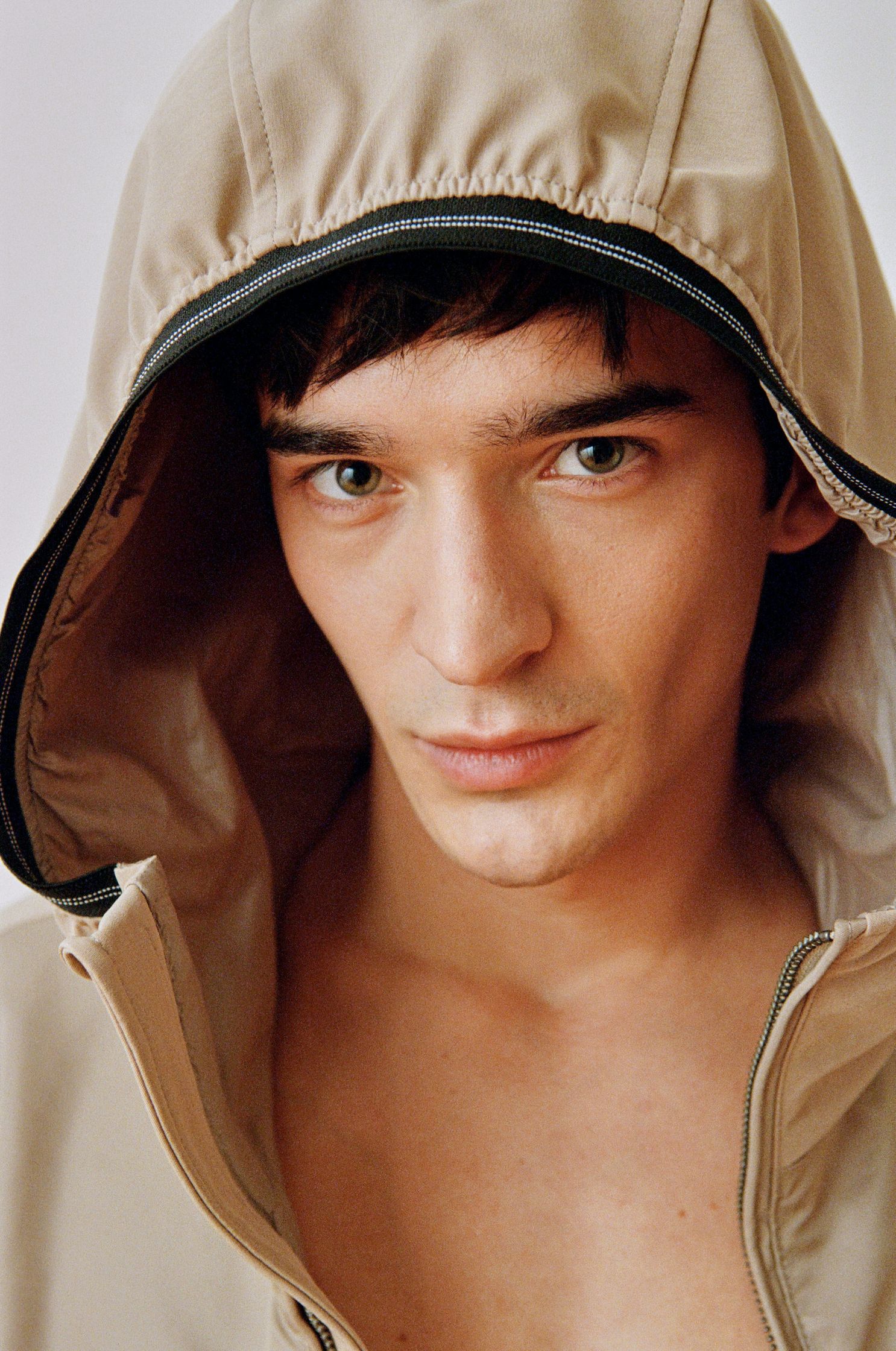 a man in a hooded jacket is posing for a photo by advertising photographer Martin Kula