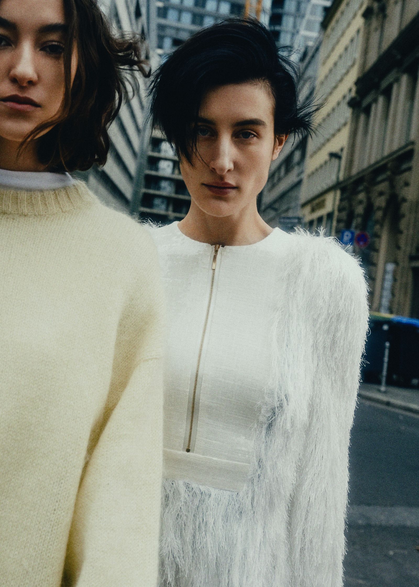 two women standing on a street in a city