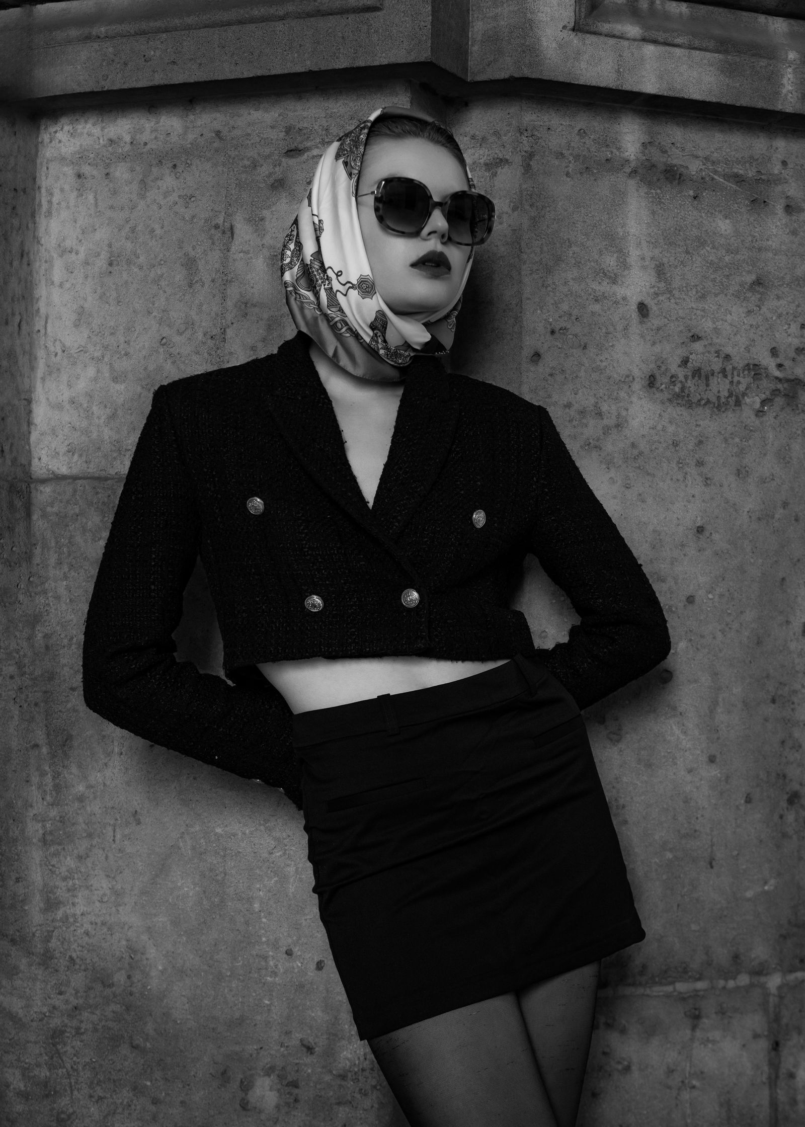 a black and white photo of a woman wearing a scarf and jacket