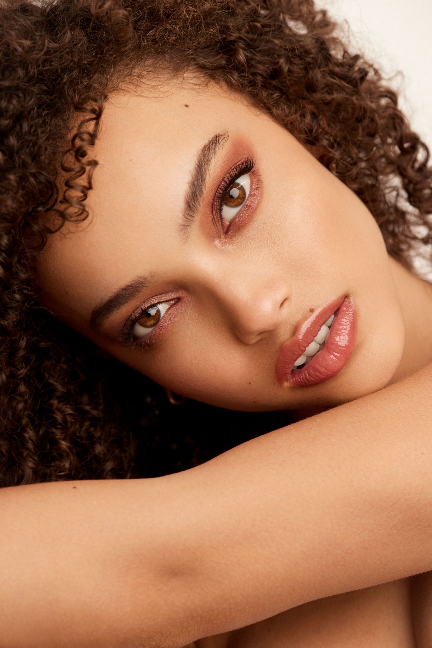 a woman with curly hair posing for a photo