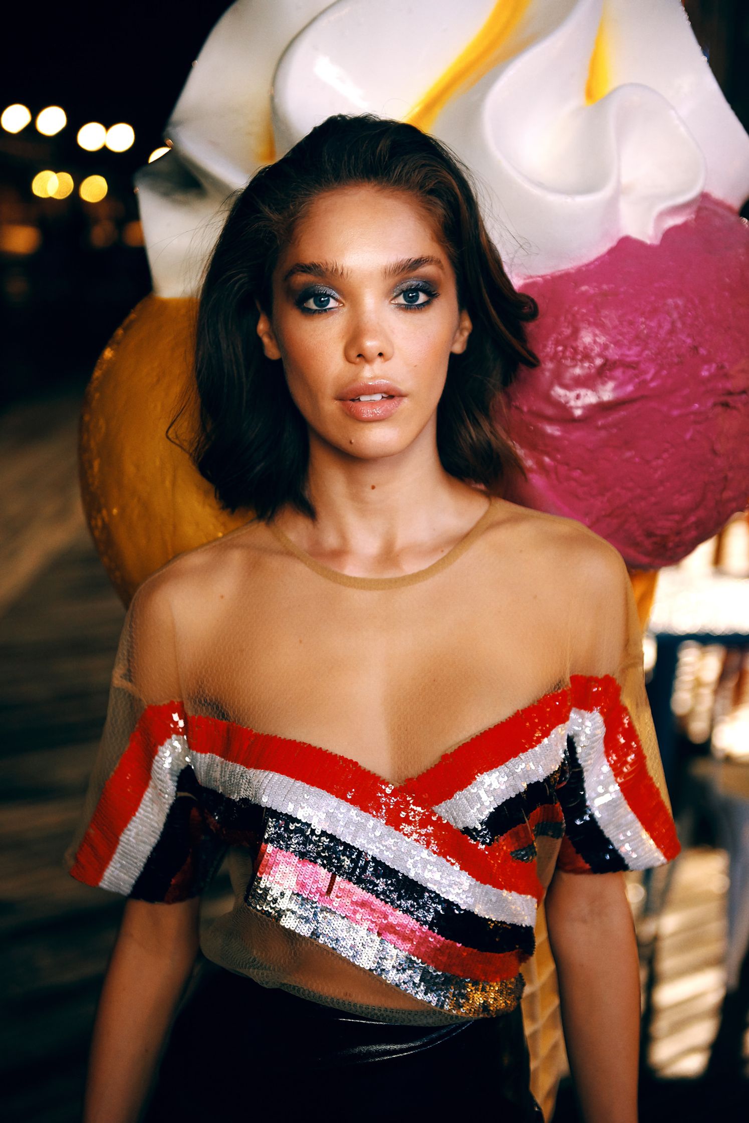 a model is posing in front of an ice cream cone
