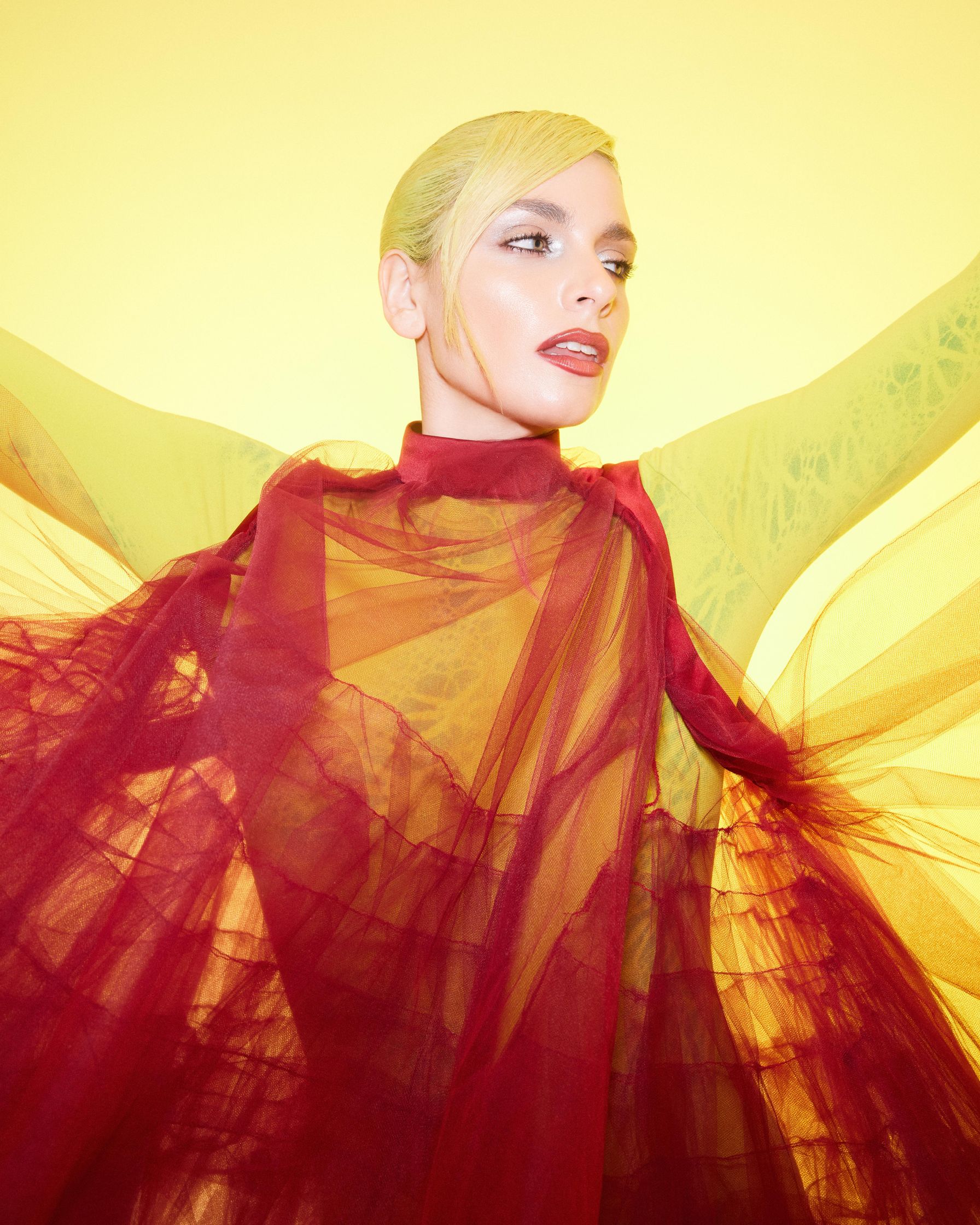 a woman in a red and yellow dress posing