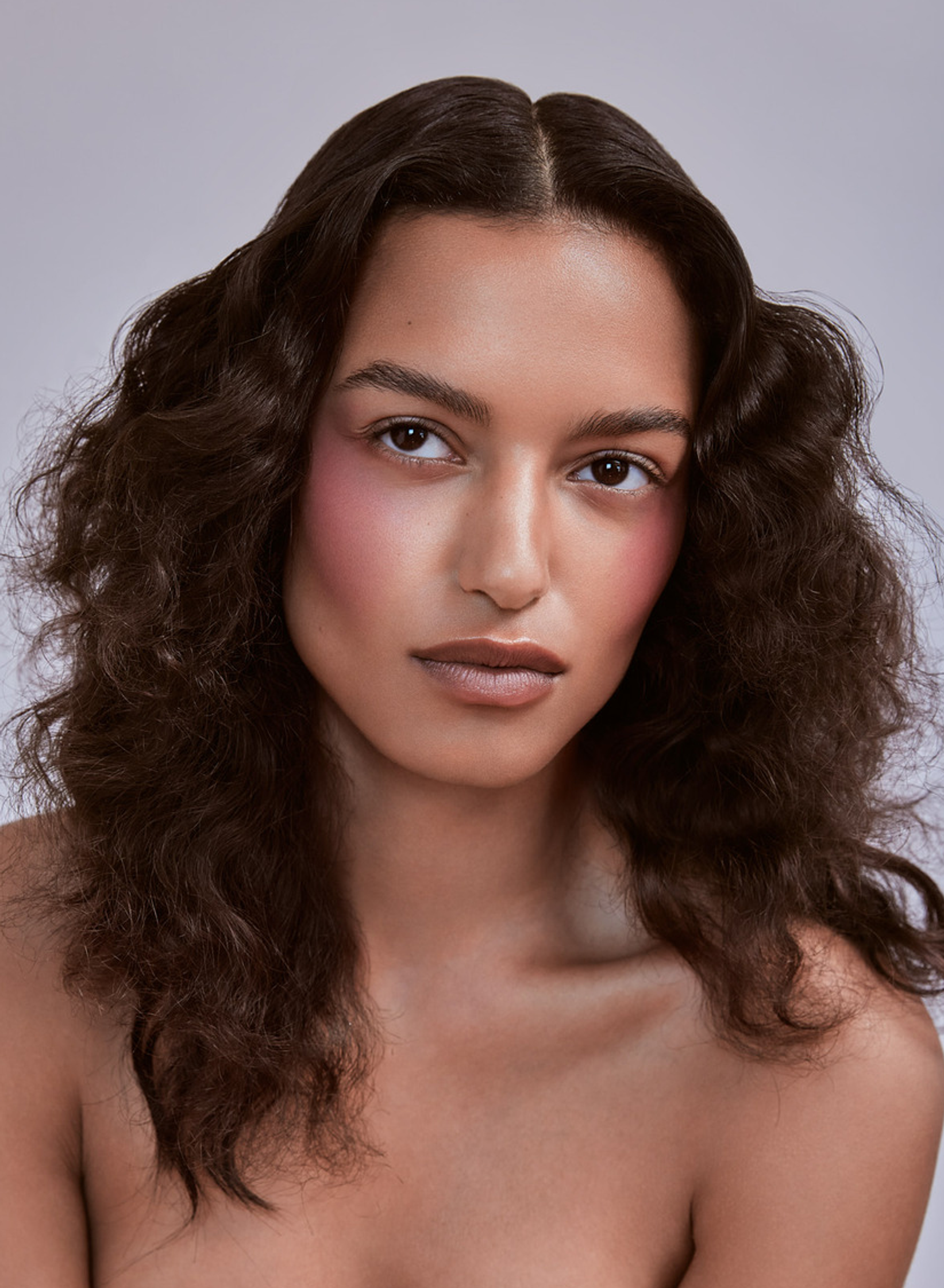 a woman with long curly hair posing for a photo