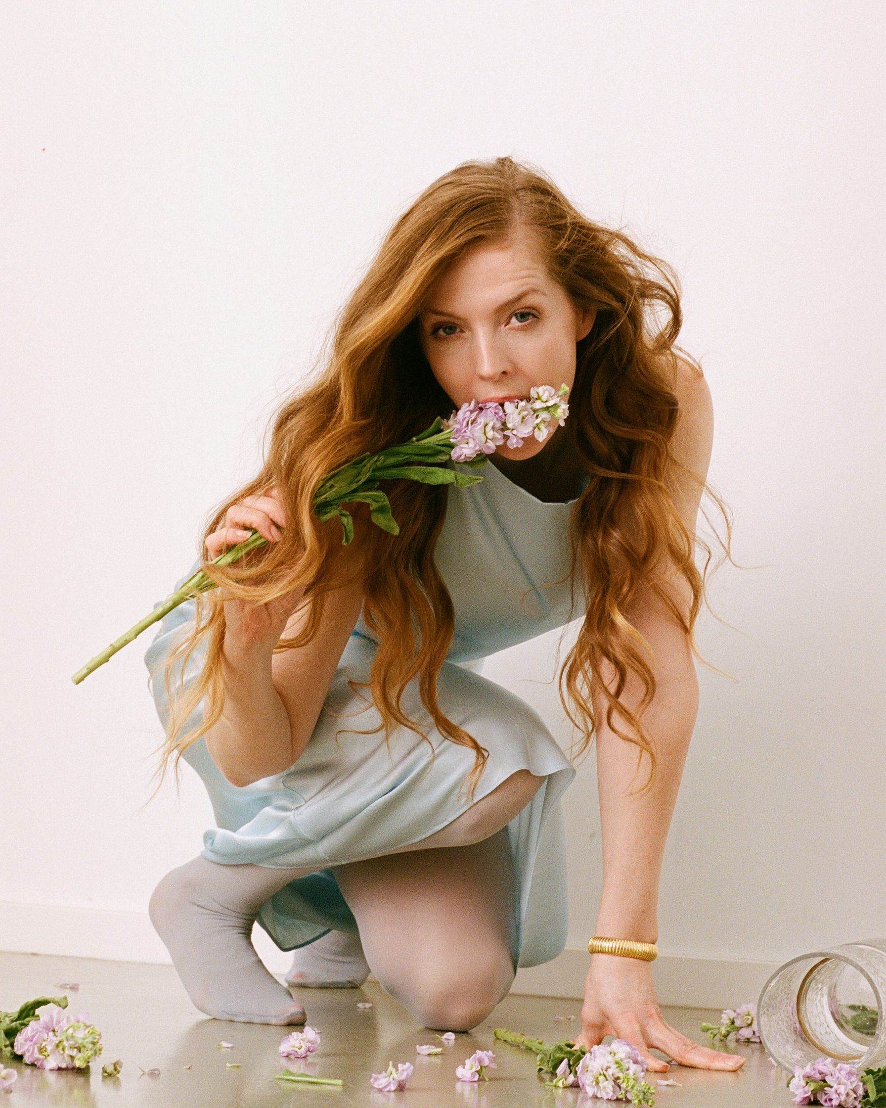 Pheline Roggan in a blue dress is holding a bouquet of flowers photographed by advertising photographer Martin Kula