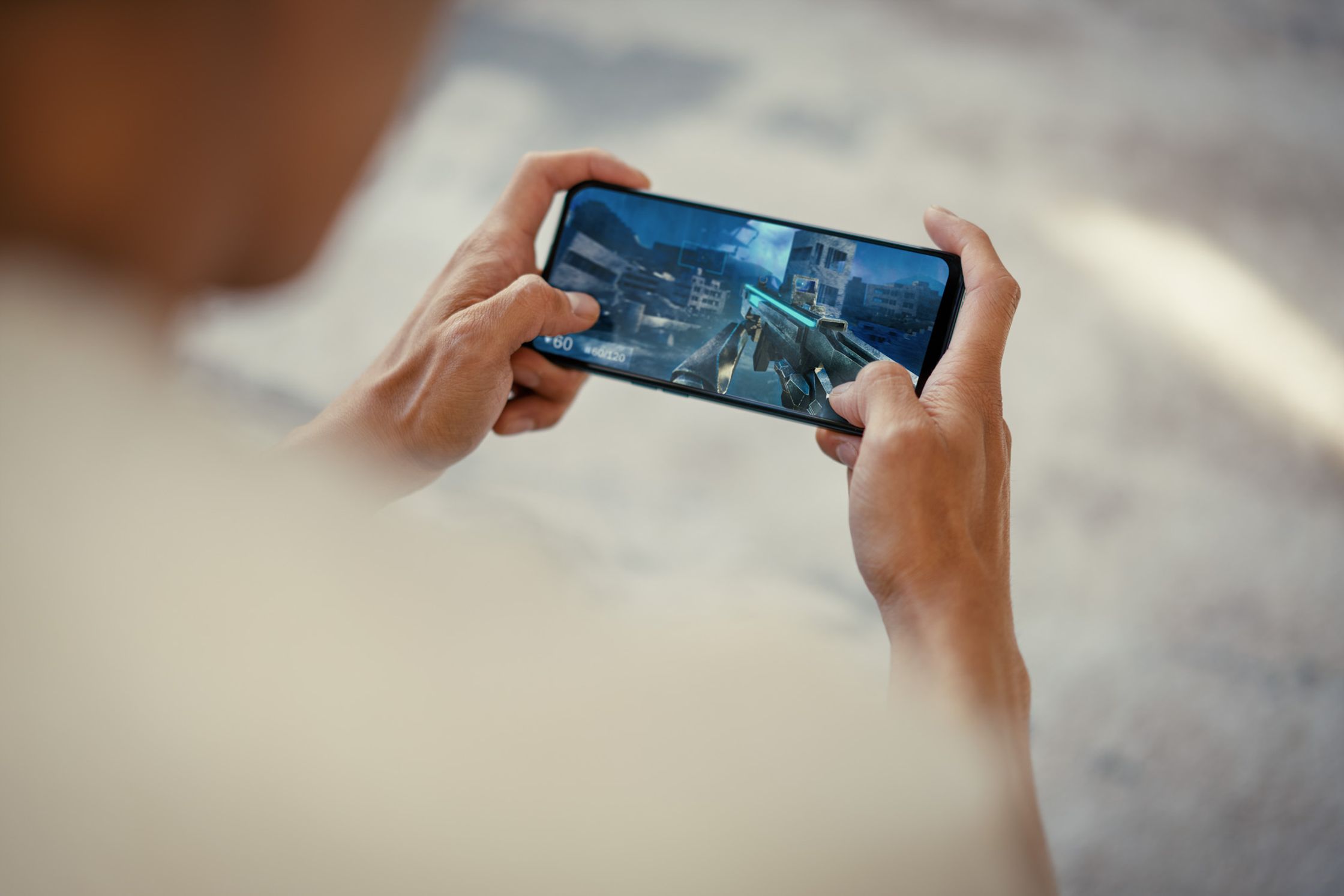 a person holding a smartphone and playing a video game