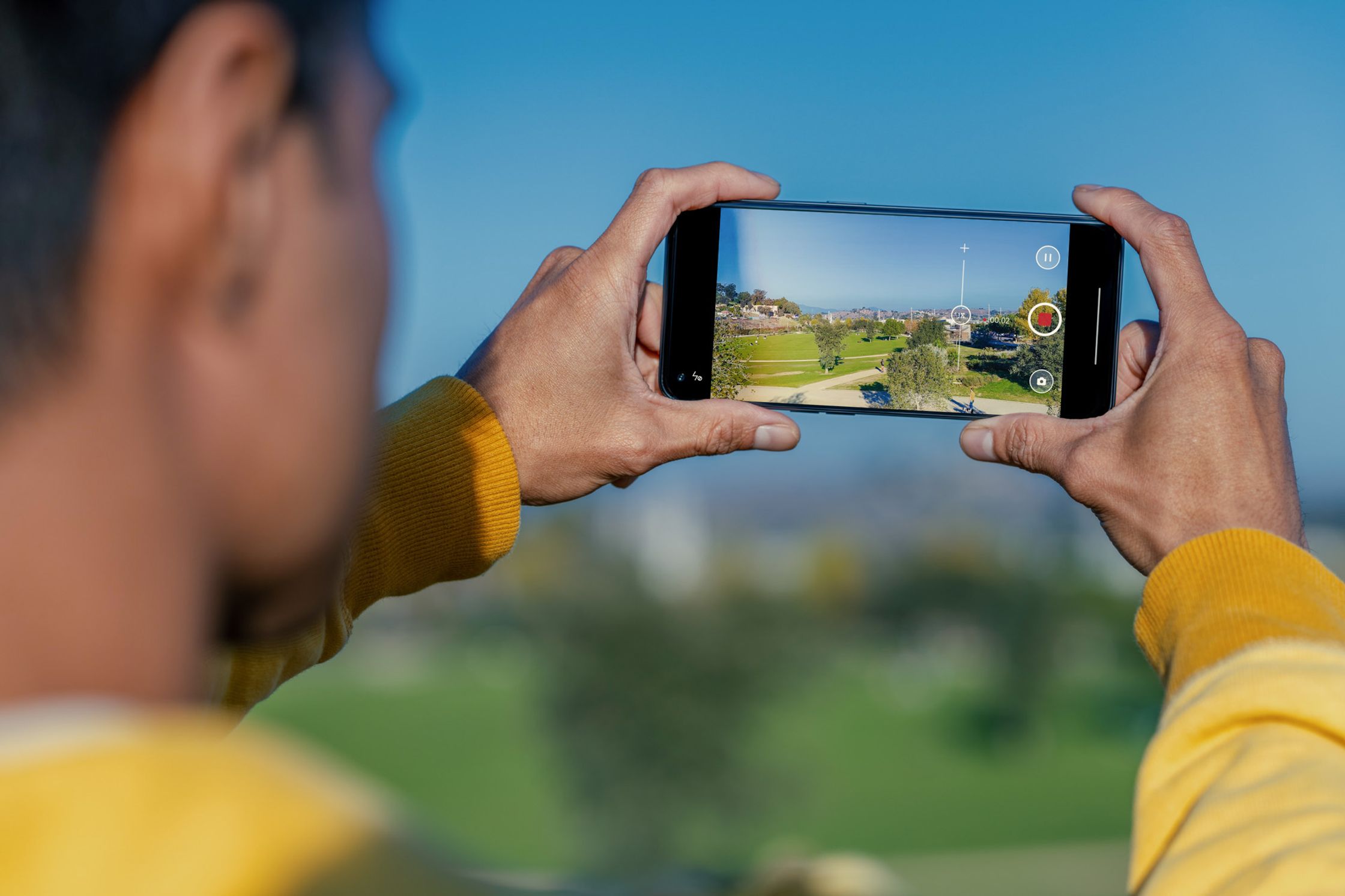 a man is taking a picture of a park with his phone