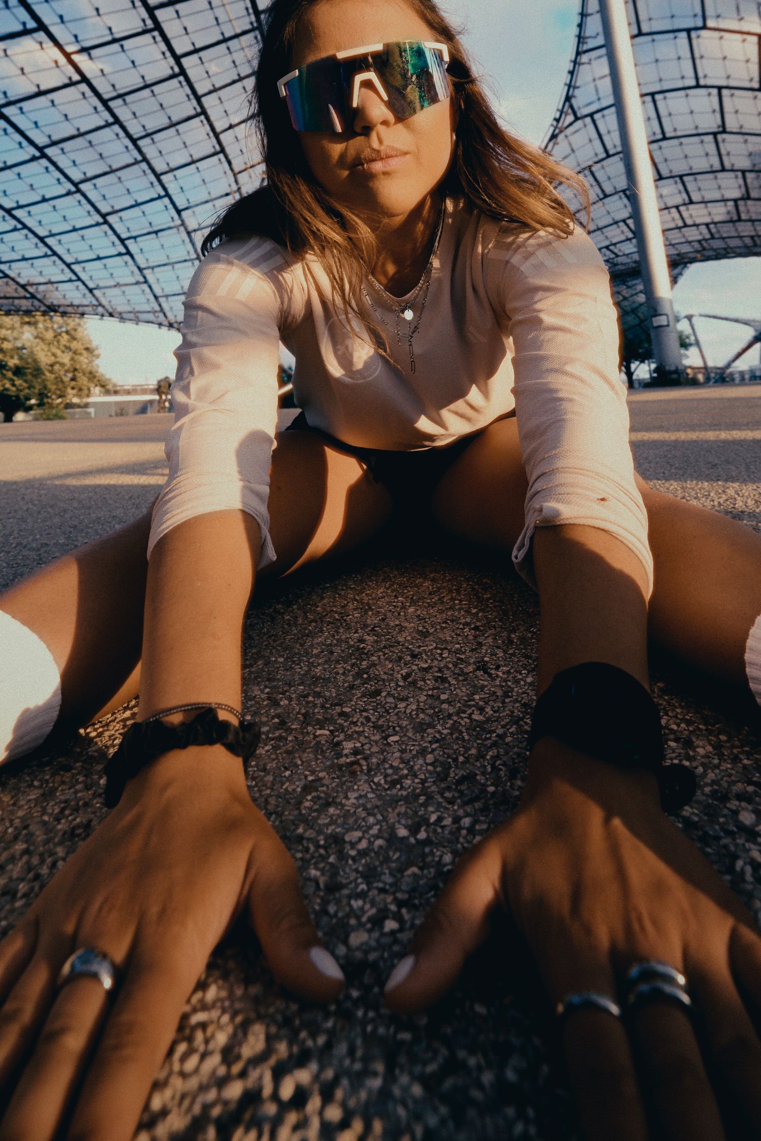 a woman wearing sunglasses crouching on the ground