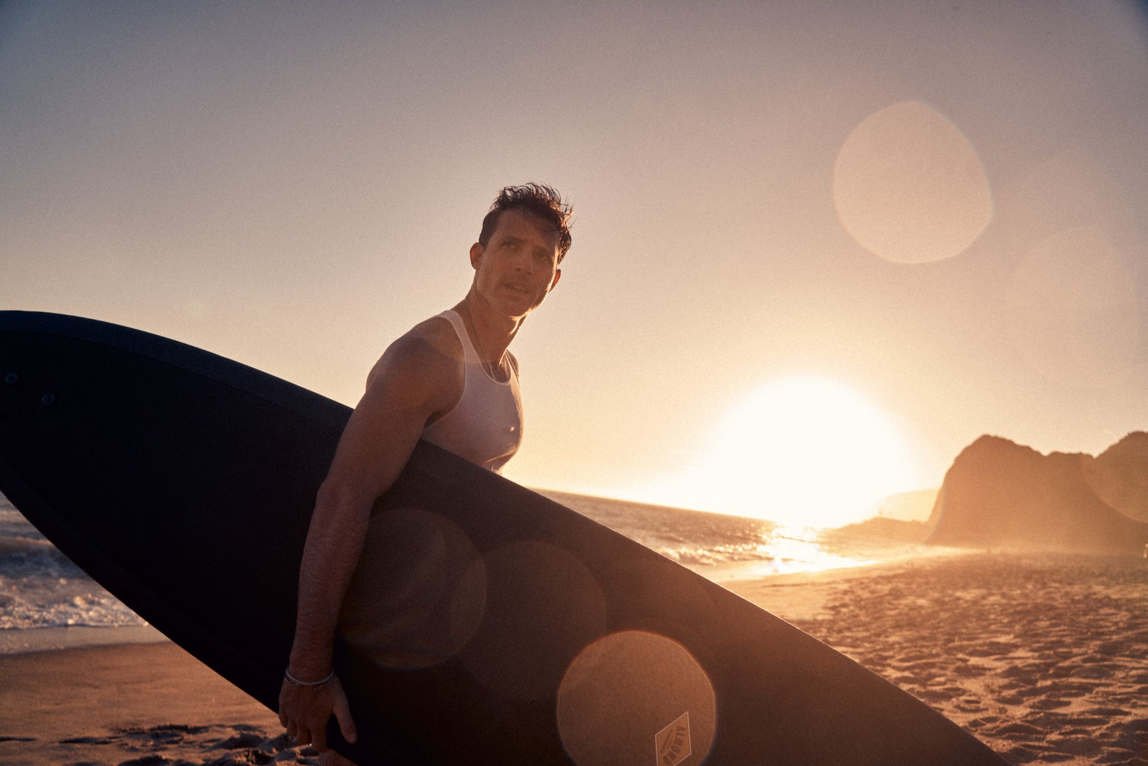 a man carrying a surfboard on the beach