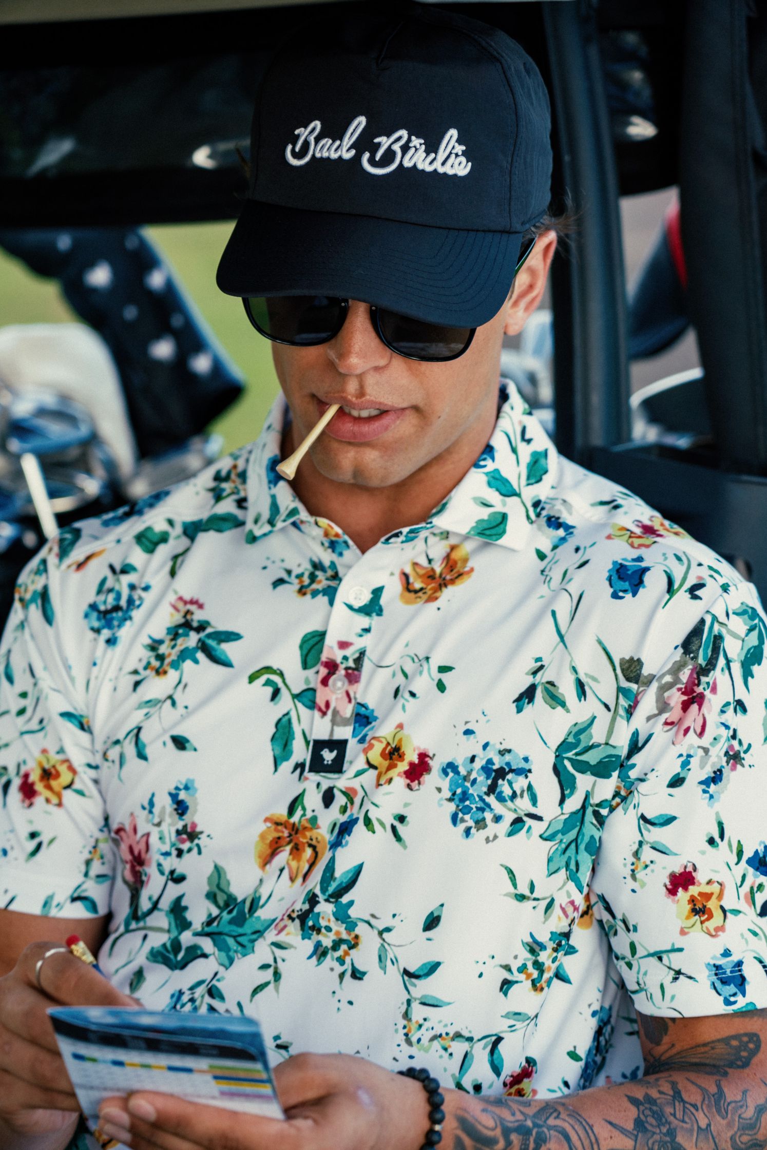 a man in a floral shirt in a golf cart