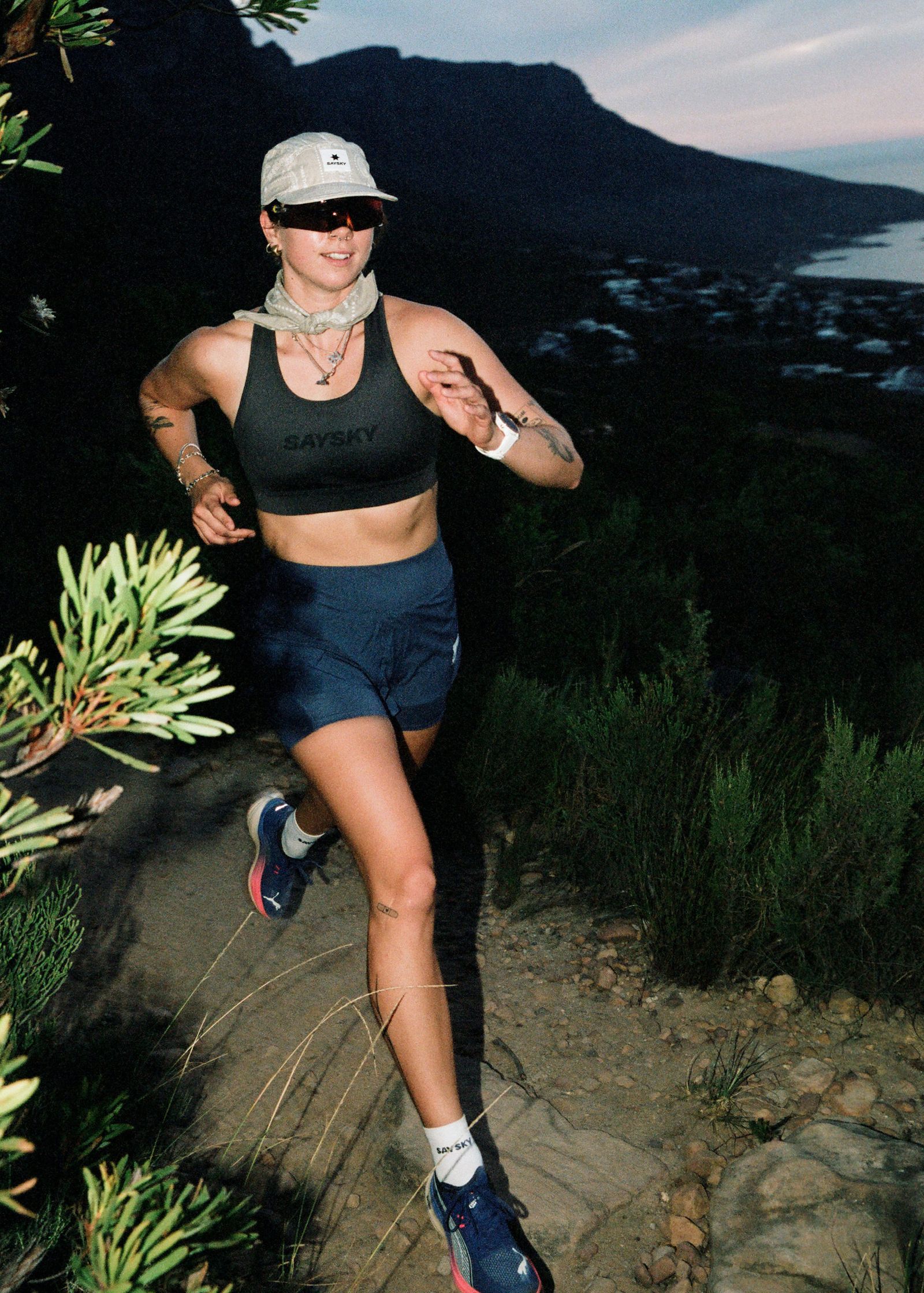 a woman running on a trail at dusk