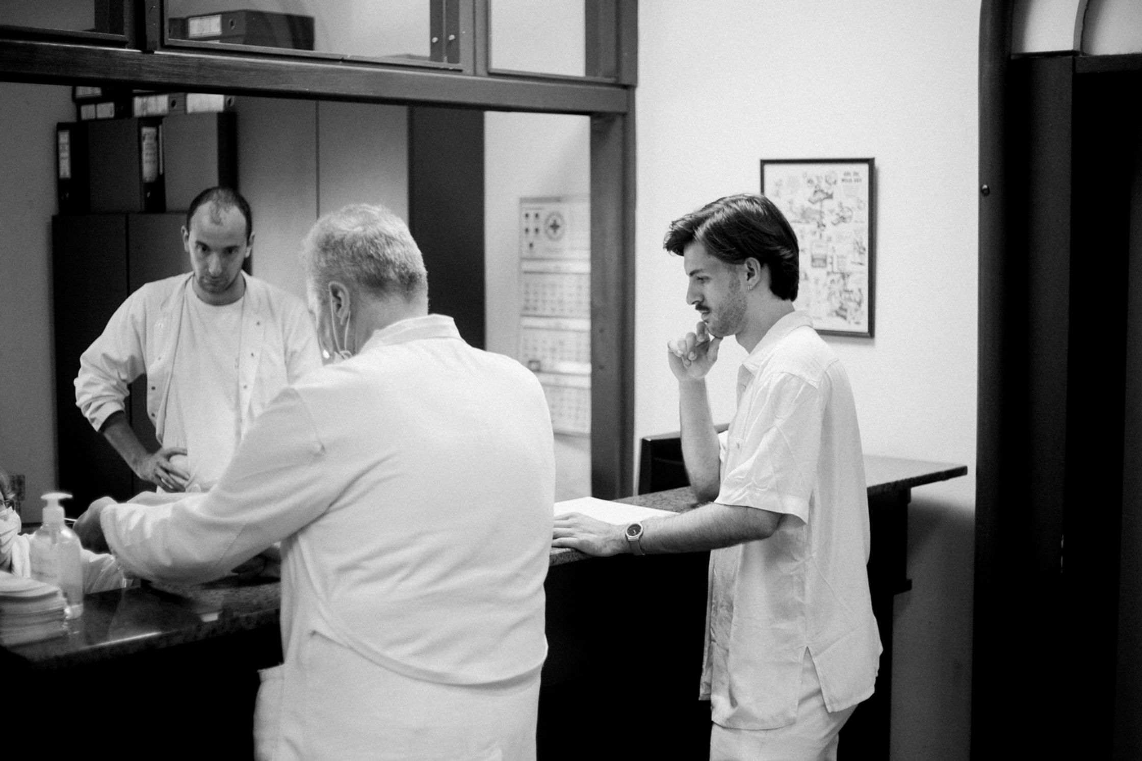 Black and white photo of three men in what looks like a medical facility.