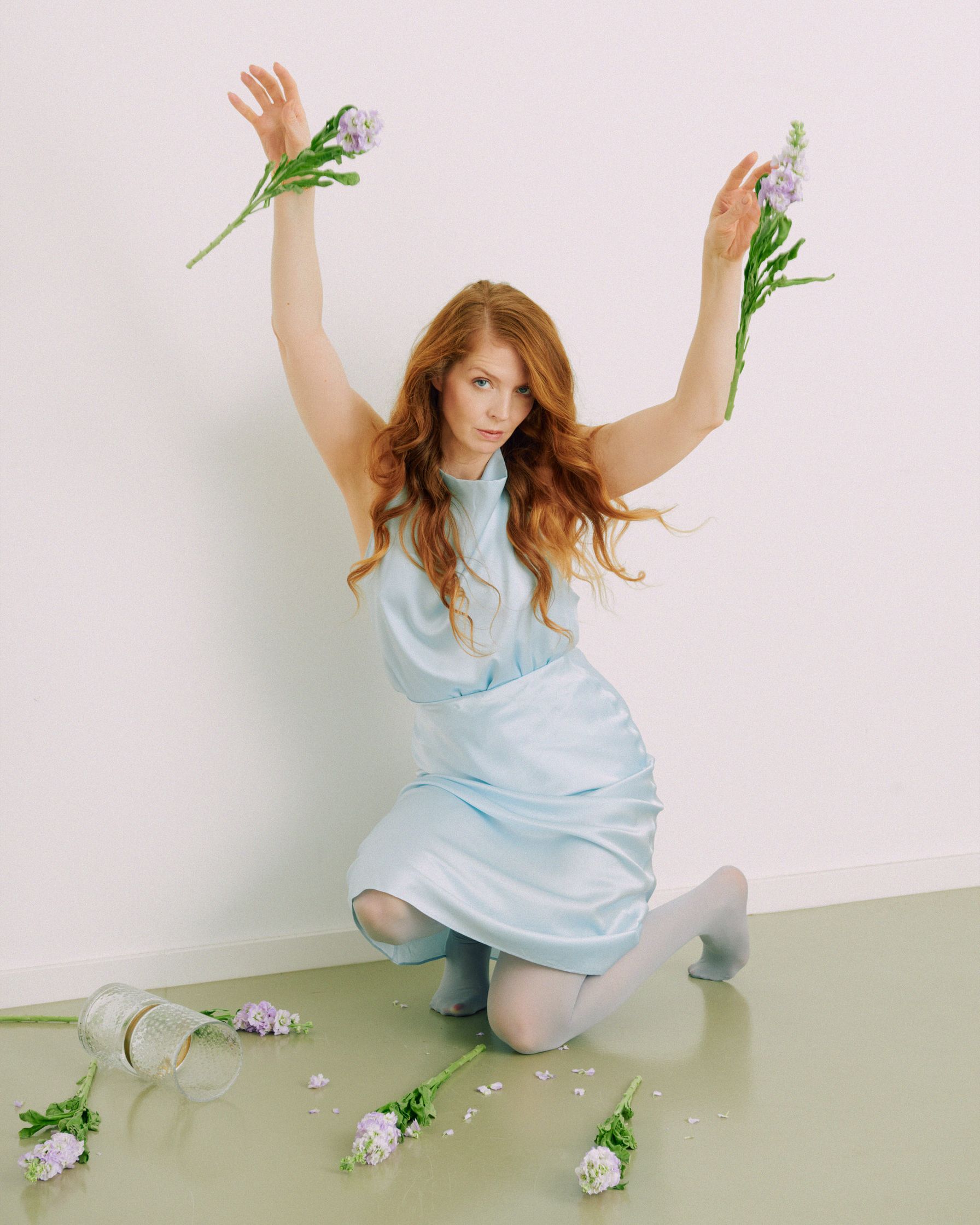 Pheline Roggan in a blue dress with flowers in her hands