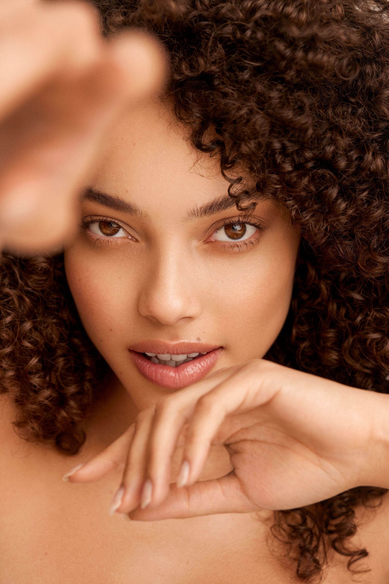 a woman with curly hair is posing for a photo