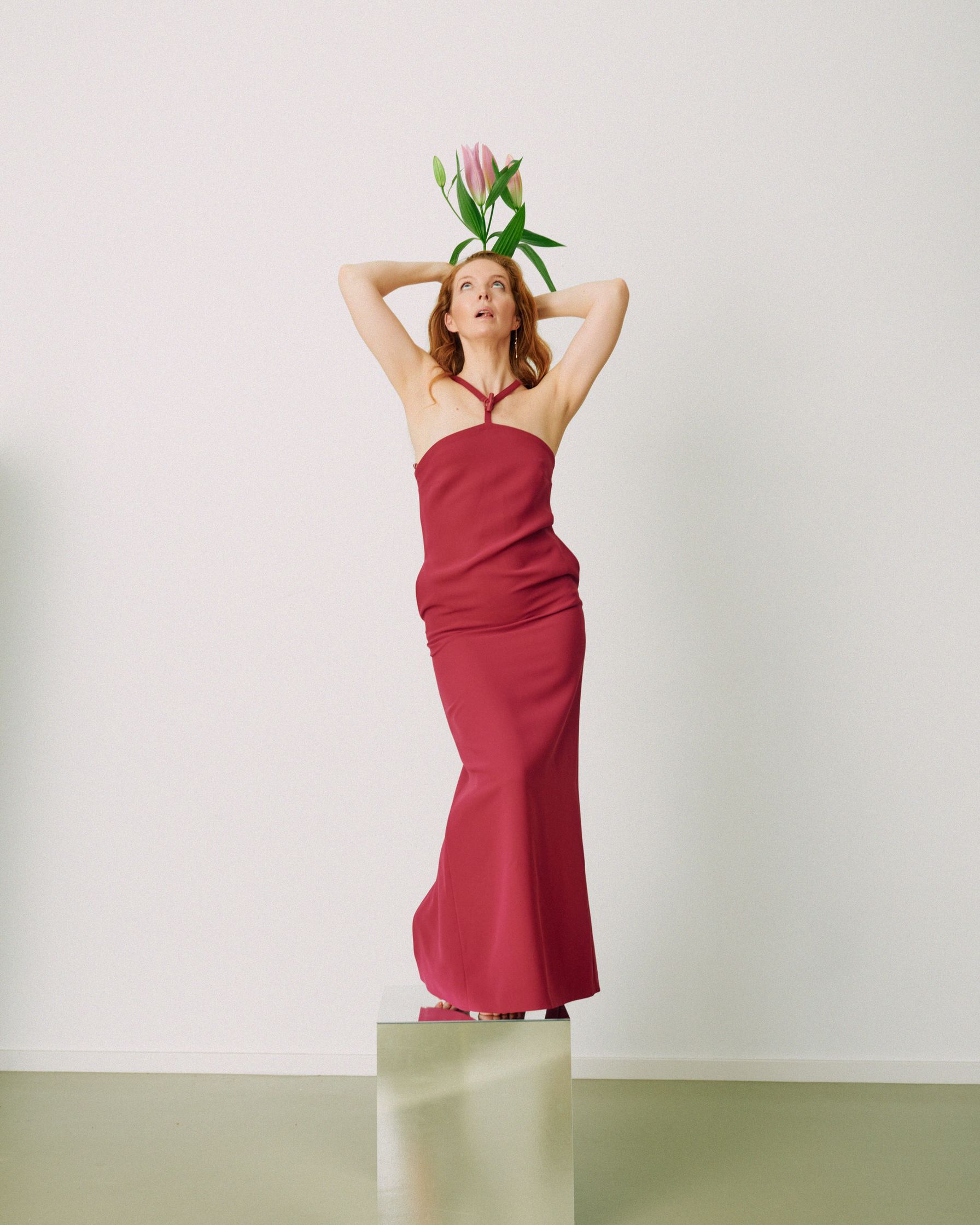 Pheline Roggan in a red dress standing on top of a square